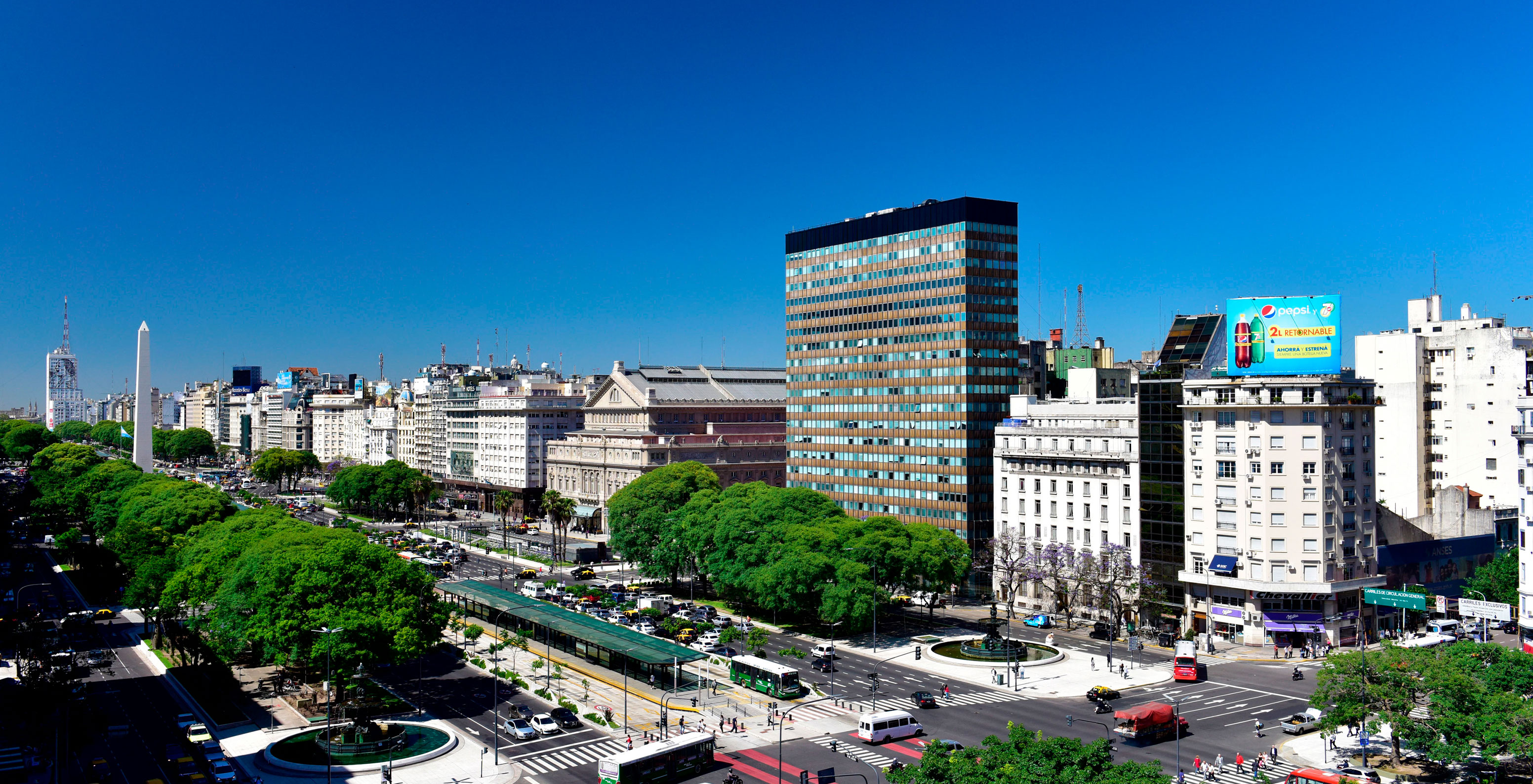 Panoramablick auf die Avenida 9 de Julio in Buenos Aires, mit ikonischen Gebäuden und mehreren bewegenden Fahrzeugen