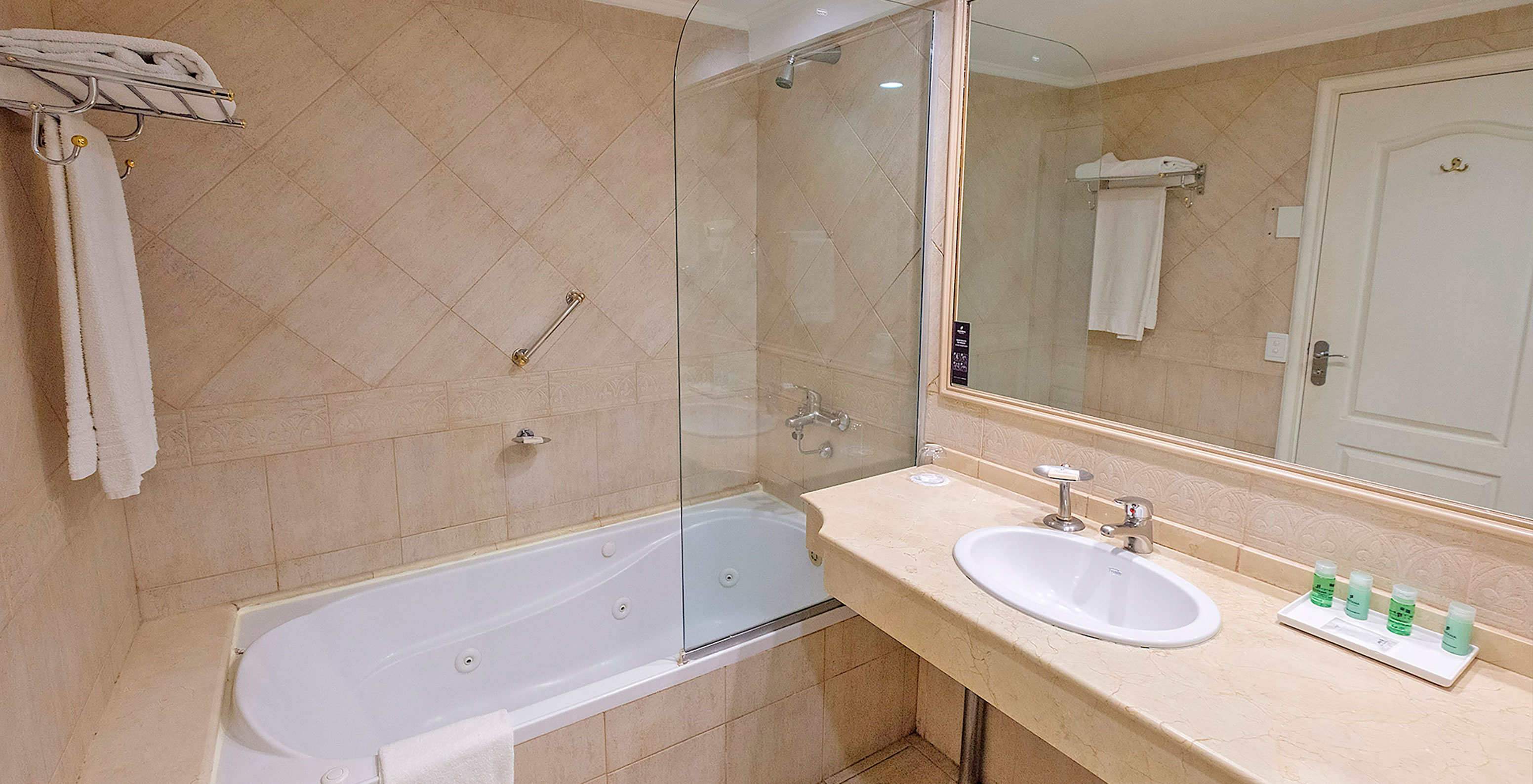 Das Twin Executive Zimmer im Pestana Buenos Aires hat ein Bad mit Waschbecken, Spiegel und Badewanne mit Dusche