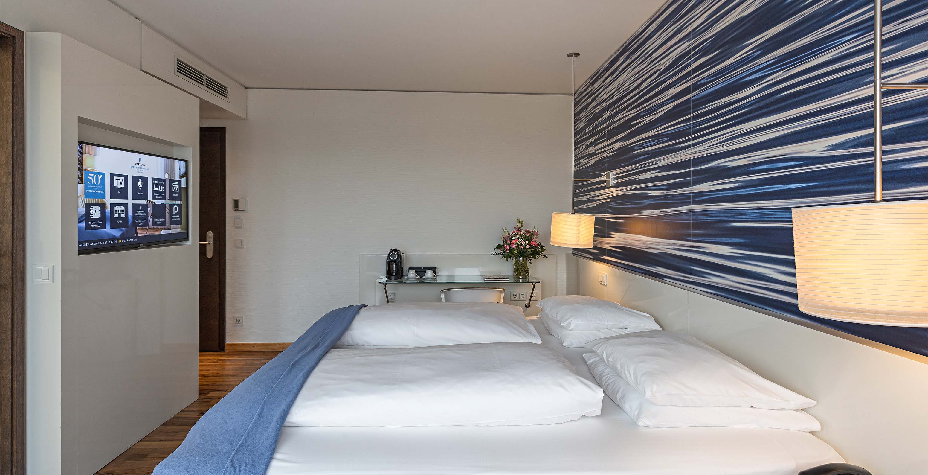 Das Premium Zimmer mit Balkon im Pestana Berlin Tiergarten hat ein Doppelbett, Fernseher und einen Schreibtisch