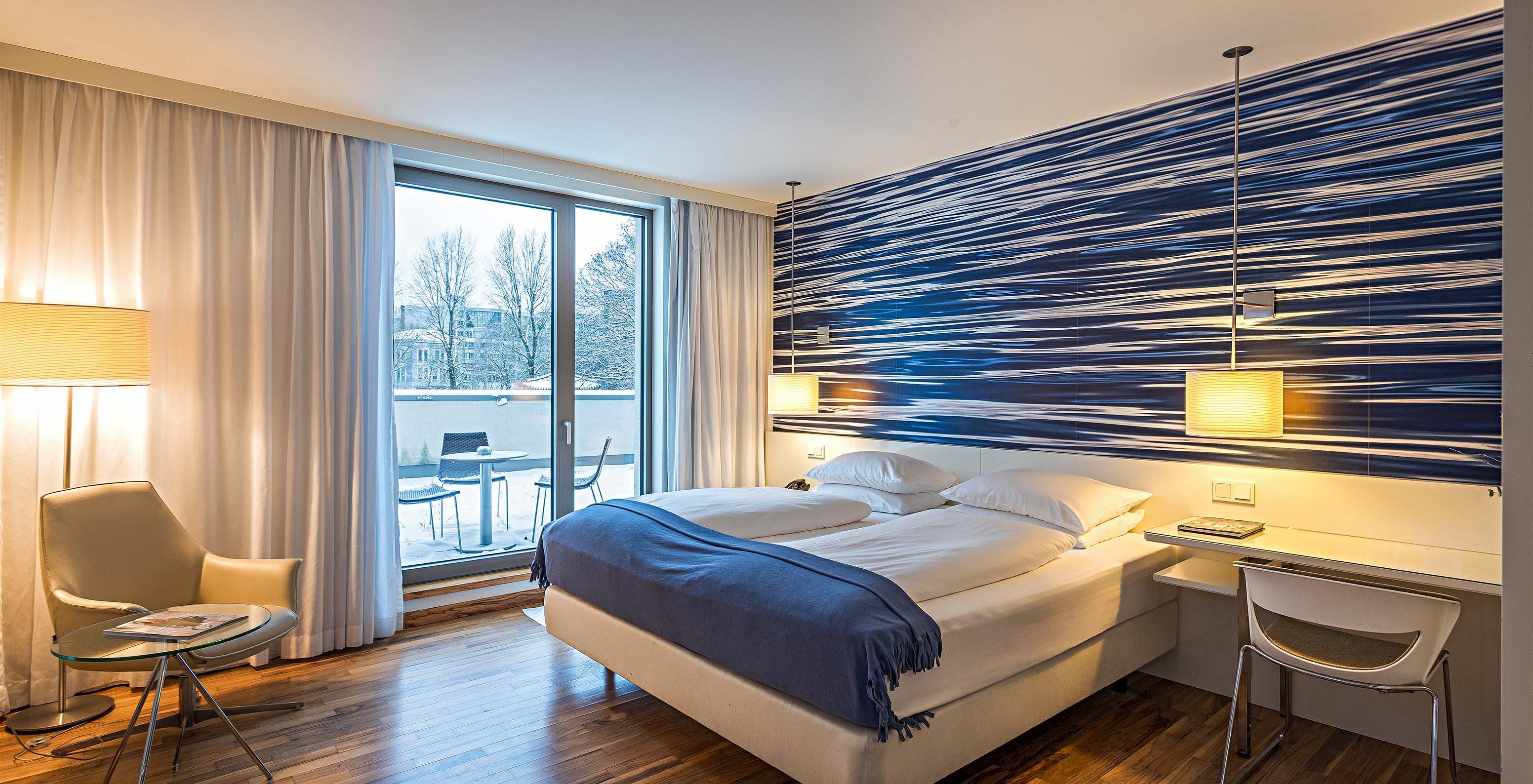 Das Deluxe Zimmer mit Terrasse im Pestana Berlin Tiergarten hat ein Doppelbett, Schreibtisch und einen Sessel