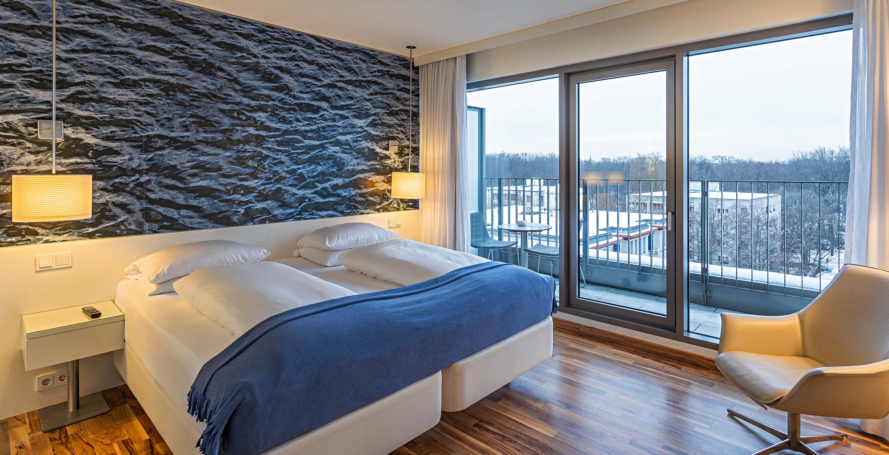 Das Premium Zimmer mit Balkon und Aussicht im Pestana Berlin Tiergarten hat ein Doppelbett, Sessel und Balkon mit Aussicht