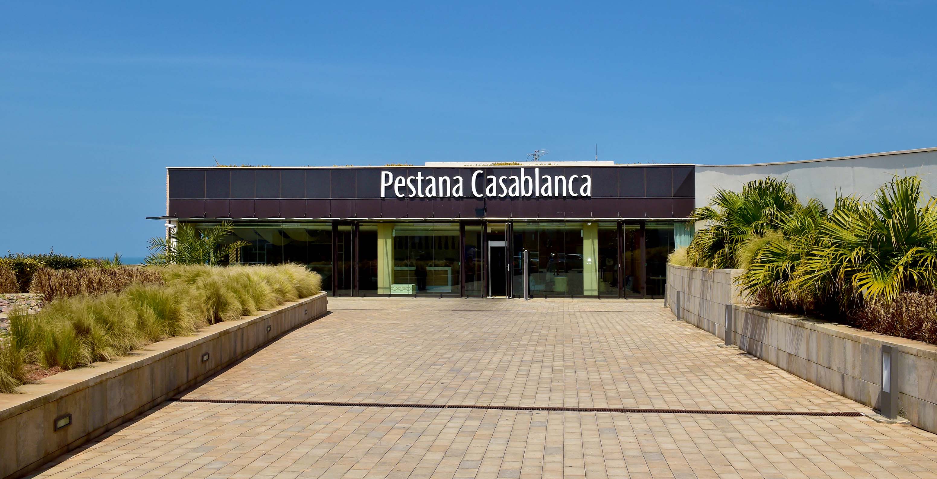 Außenansicht des Eingangs des Pestana Casablanca in Marokko, mit dem Meer im Hintergrund