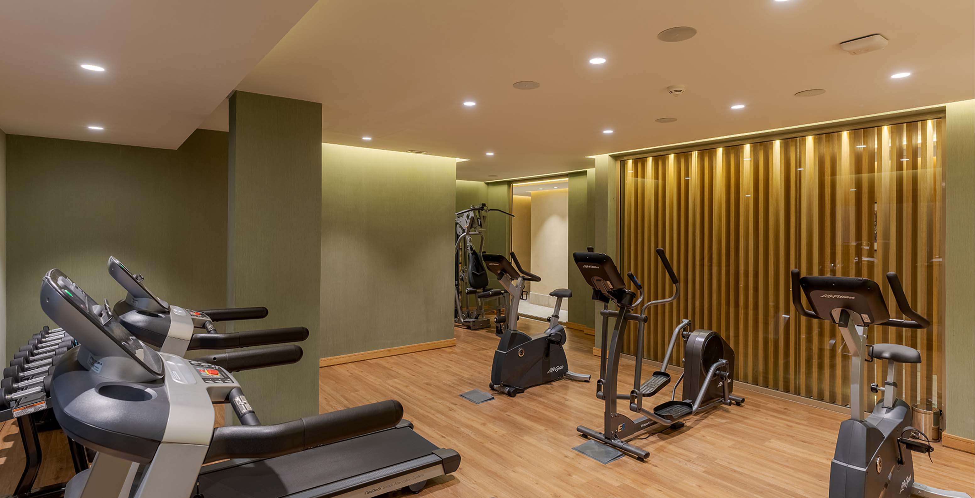 Fitnesscenter mit Laufband, Fahrrad und Gewichten für die Gäste im Lifestyle-Hotel in Marokko mit Pool