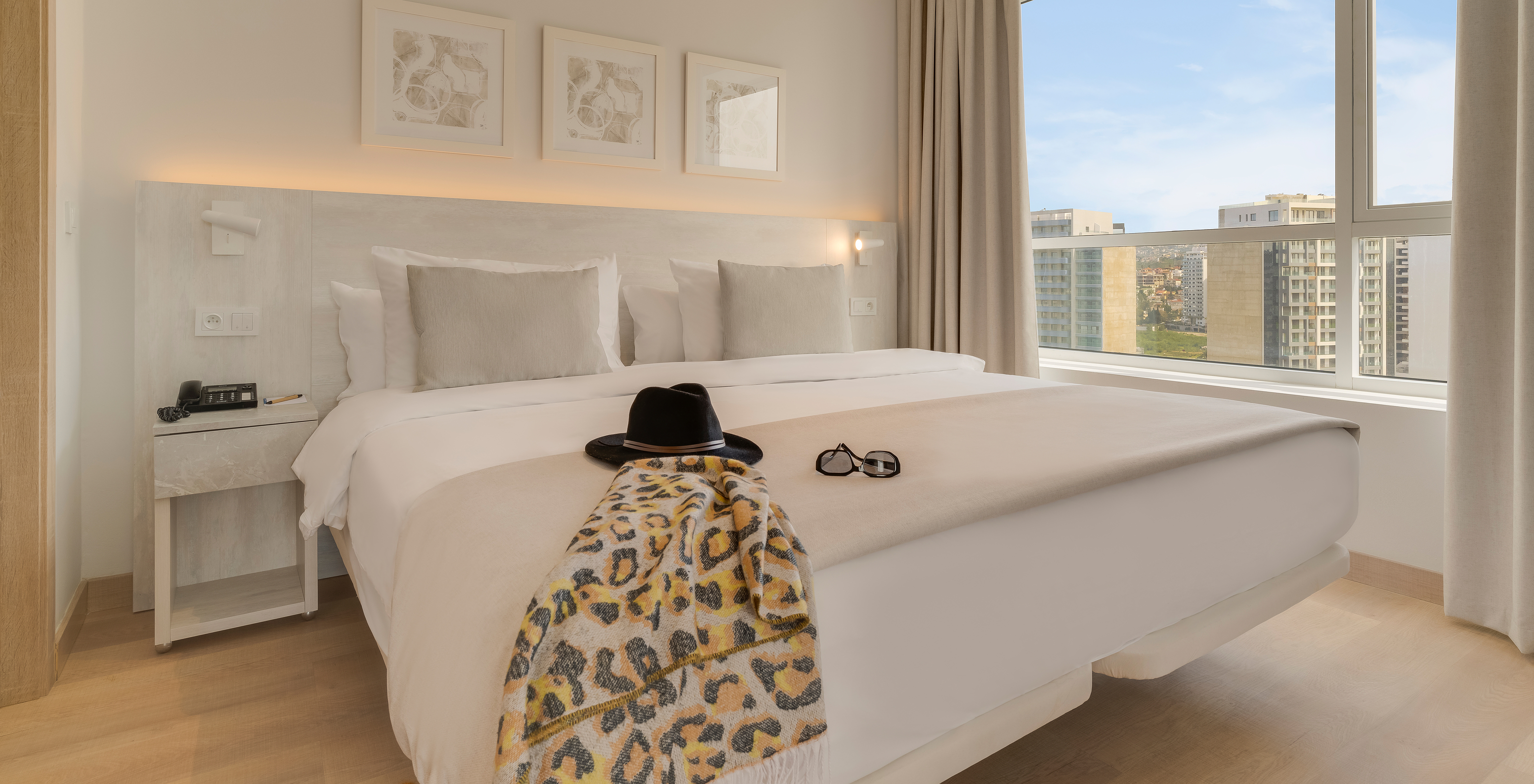 Die Premium-Suite im Pestana Tanger City Center hat ein Doppelbett mit Stein-Kopfteil und ein Fenster mit Aussicht