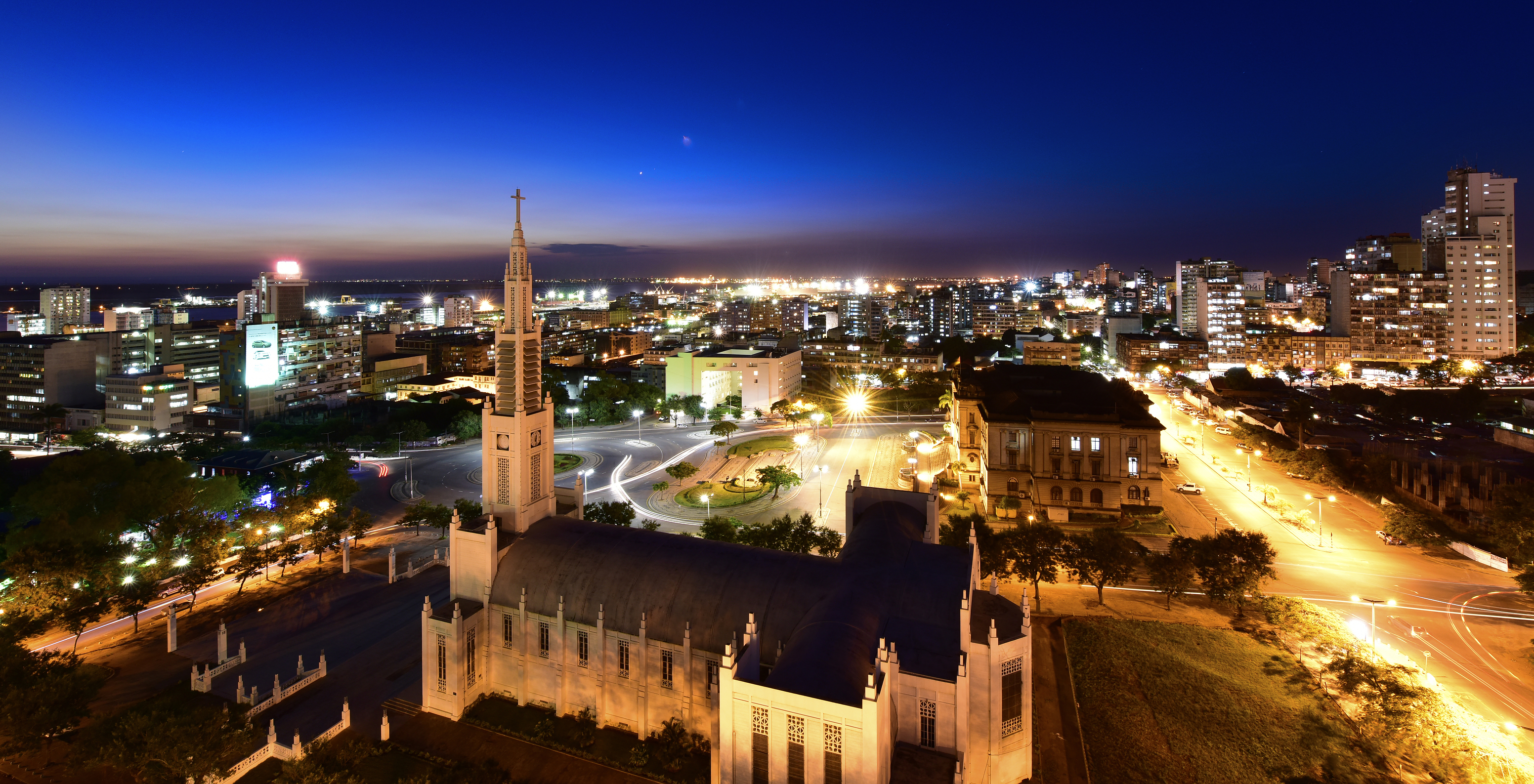 Stadt Maputo bei Nacht mit der Kathedrale von Maputo und mehreren beleuchteten Gebäuden und Häusern