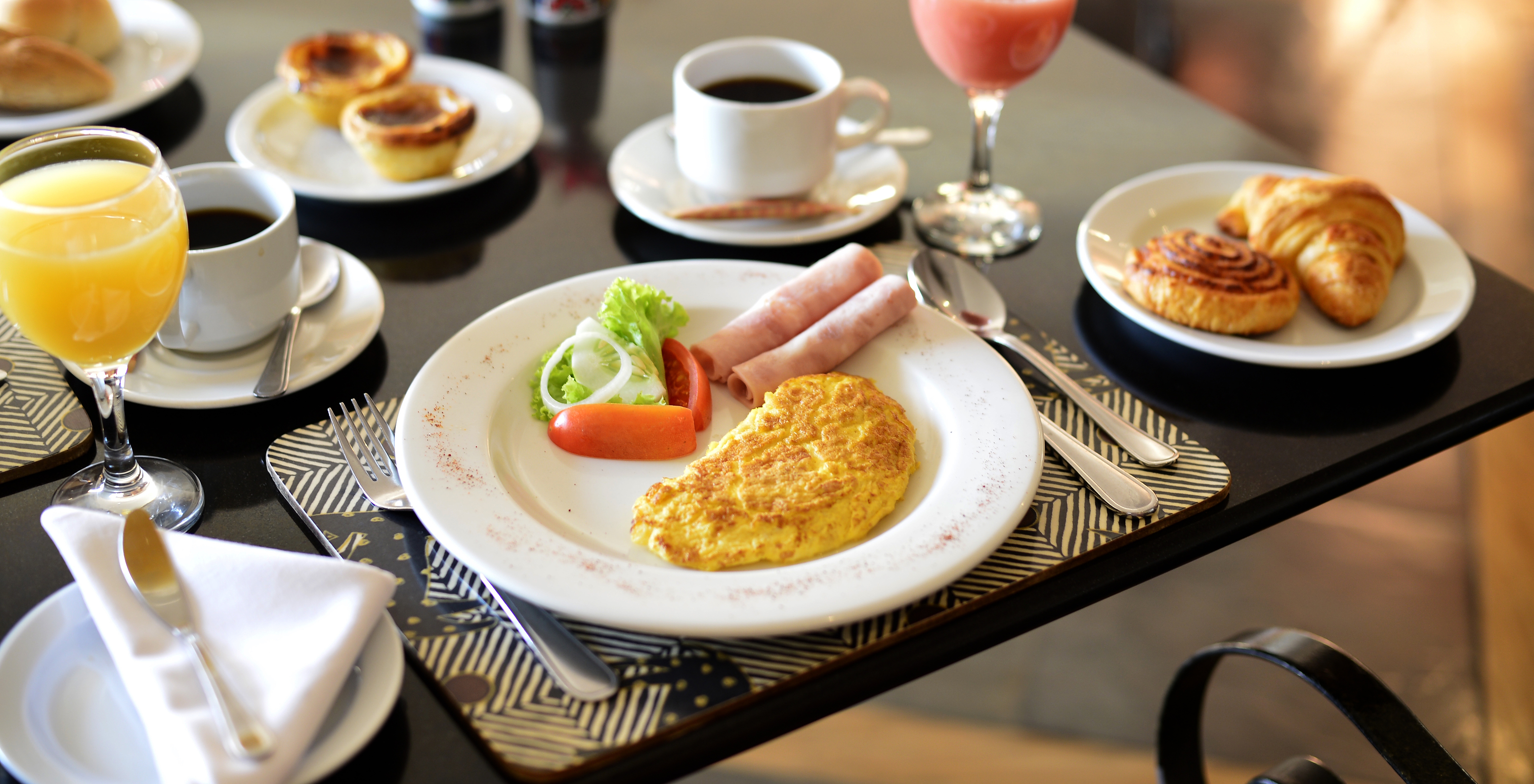 Frühstück im Hotel im Zentrum von Maputo mit Optionen wie Kaffee, Fruchtsäften, Kuchen, Eiern und Schinken