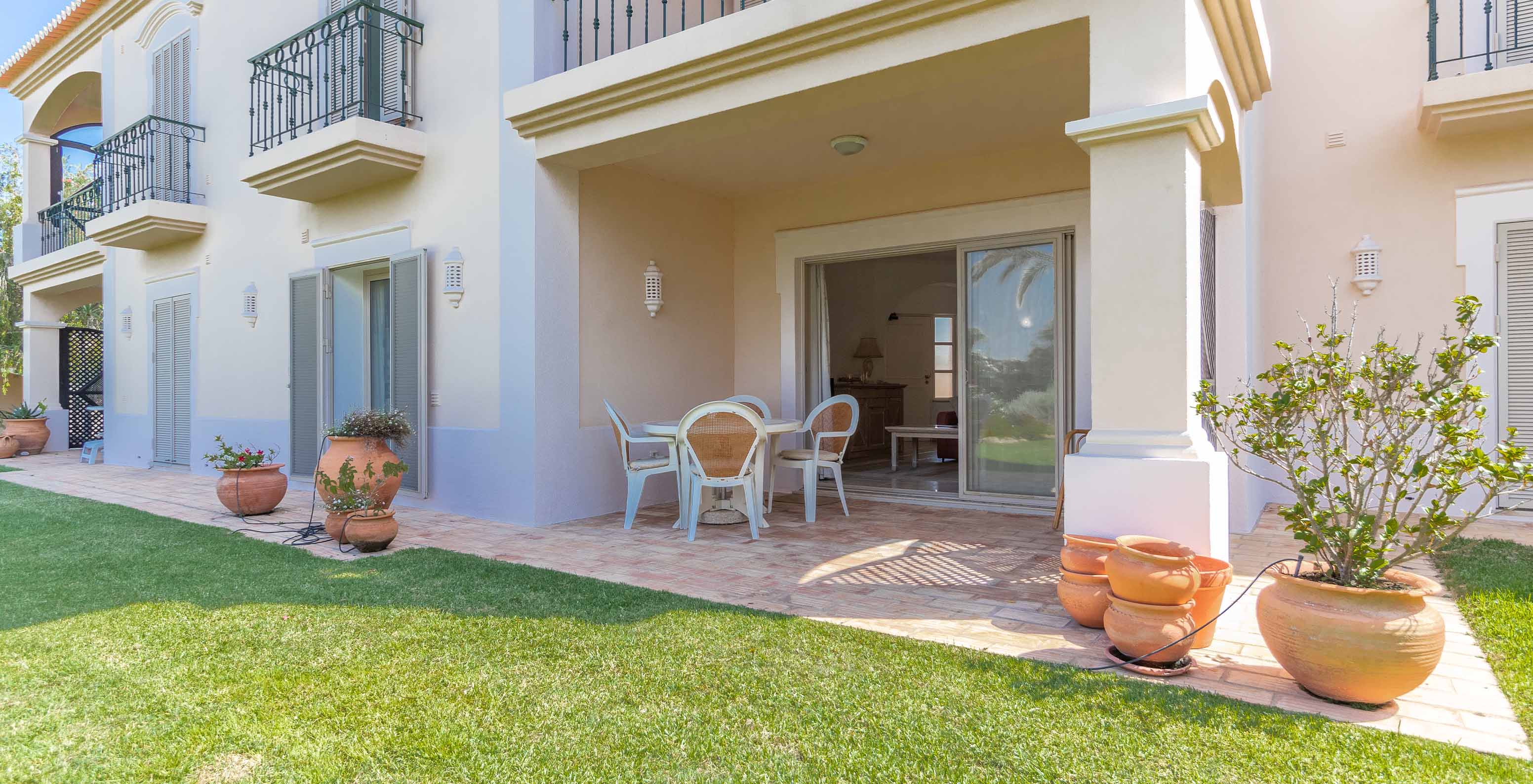 Balkon mit Tisch, Stühlen und Zugang zum Garten des Pestana Carvoeiro Golf, einem 4-Sterne-Hotel in der Algarve mit Pool