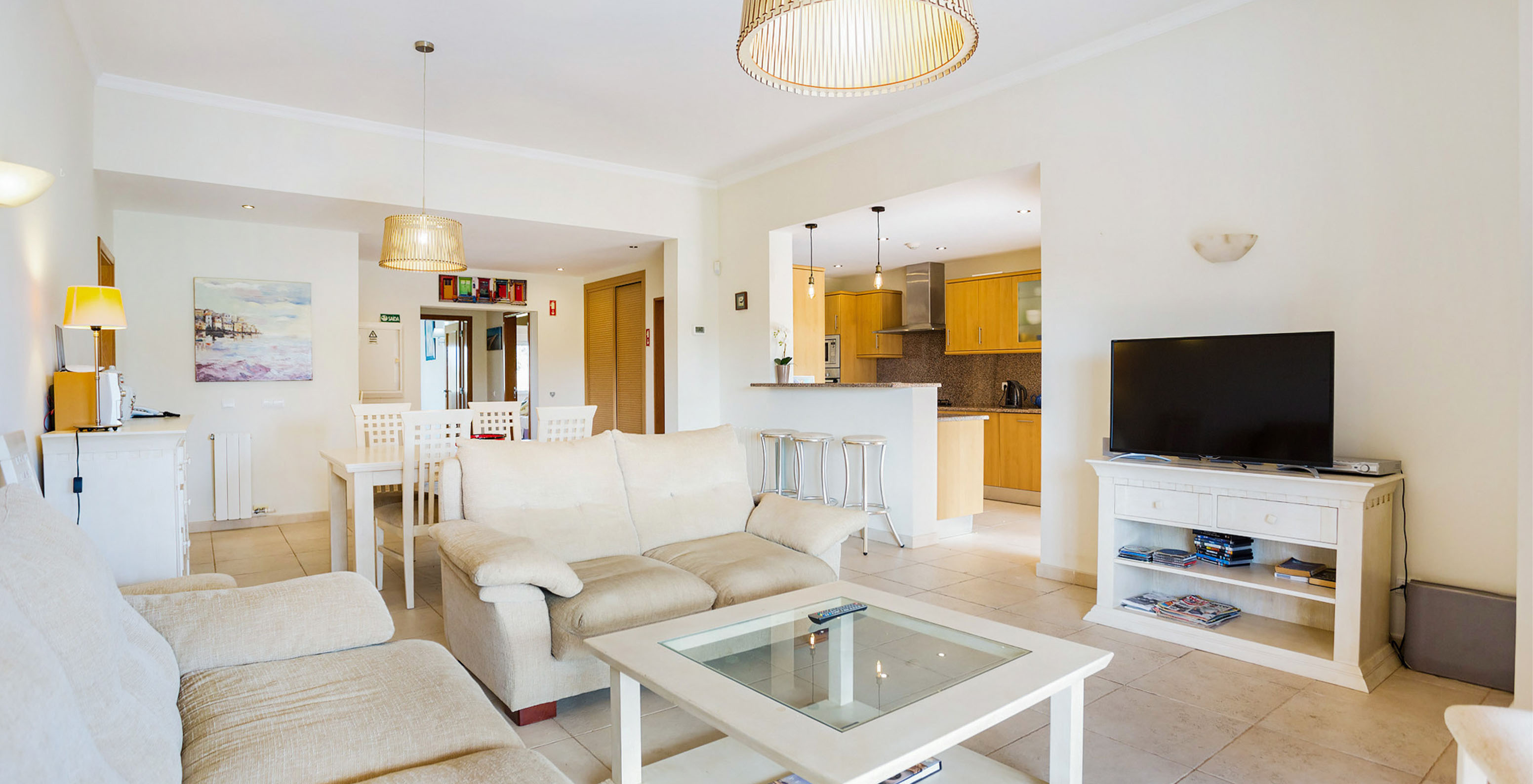 Das T3-Apartment im Pestana Carvoeiro Golf hat ein geräumiges Wohnzimmer mit Sofas, Fernseher, Tisch und offener Küche