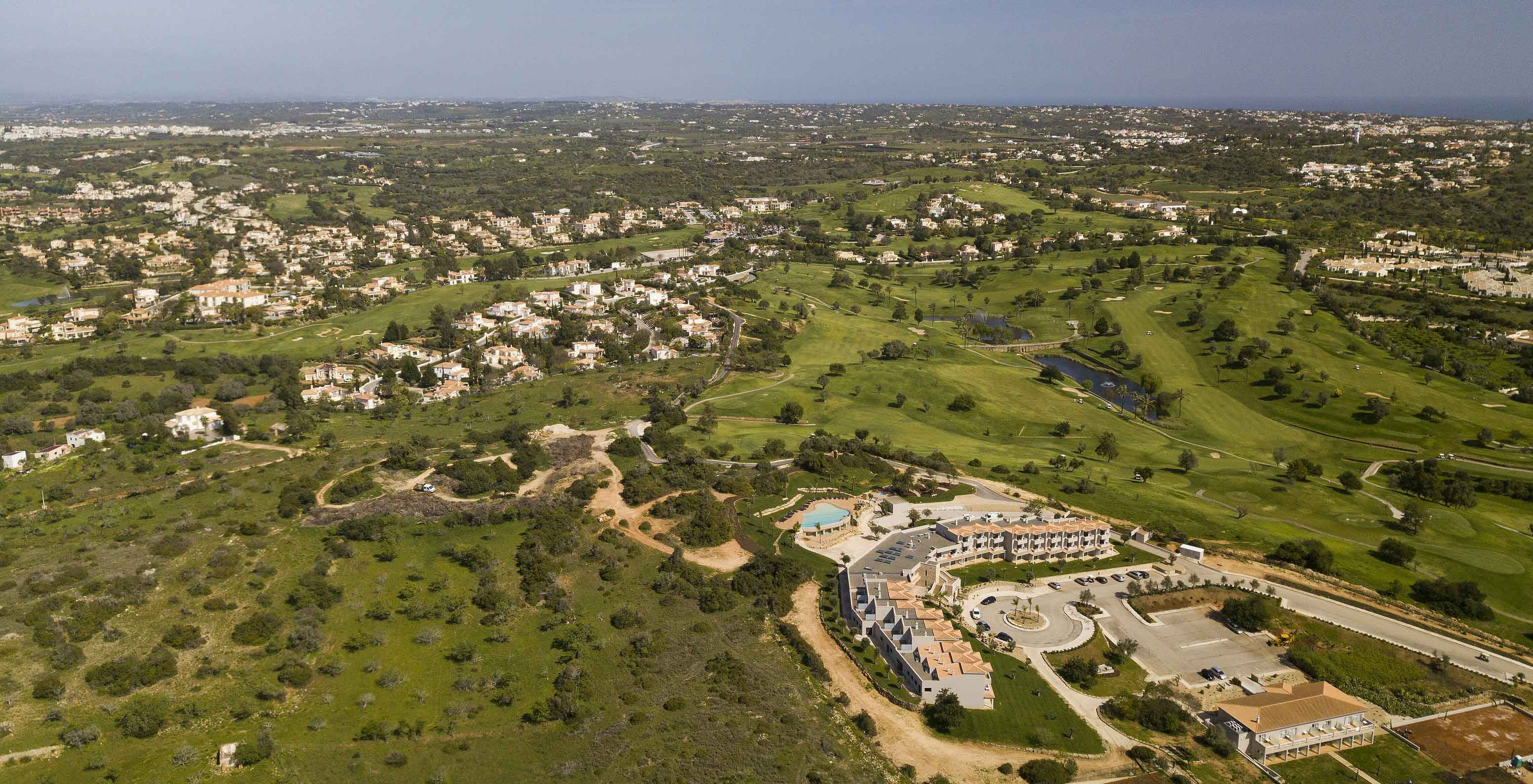 Luftaufnahme des Geländes des Pestana Gramacho Residences, mit grünen Feldern und Häusern