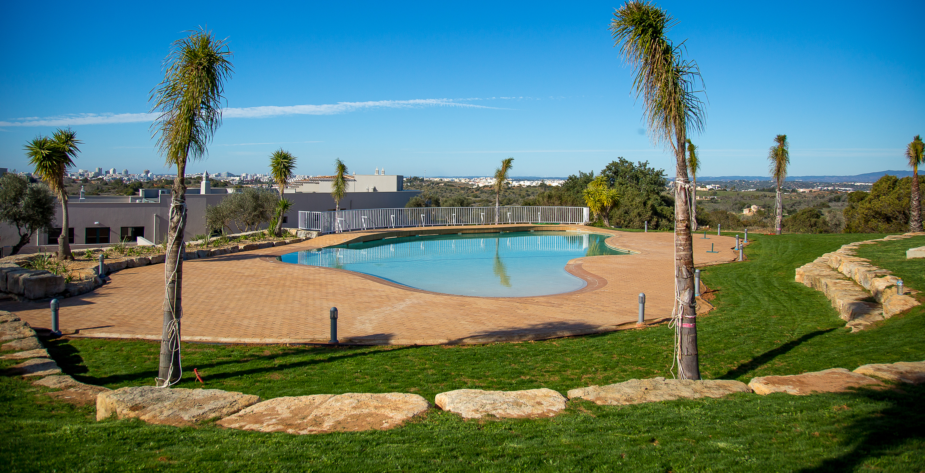 Außenpool des Pestana Gramacho Residences, umgeben von Vegetation mit Panoramablick auf die Stadt