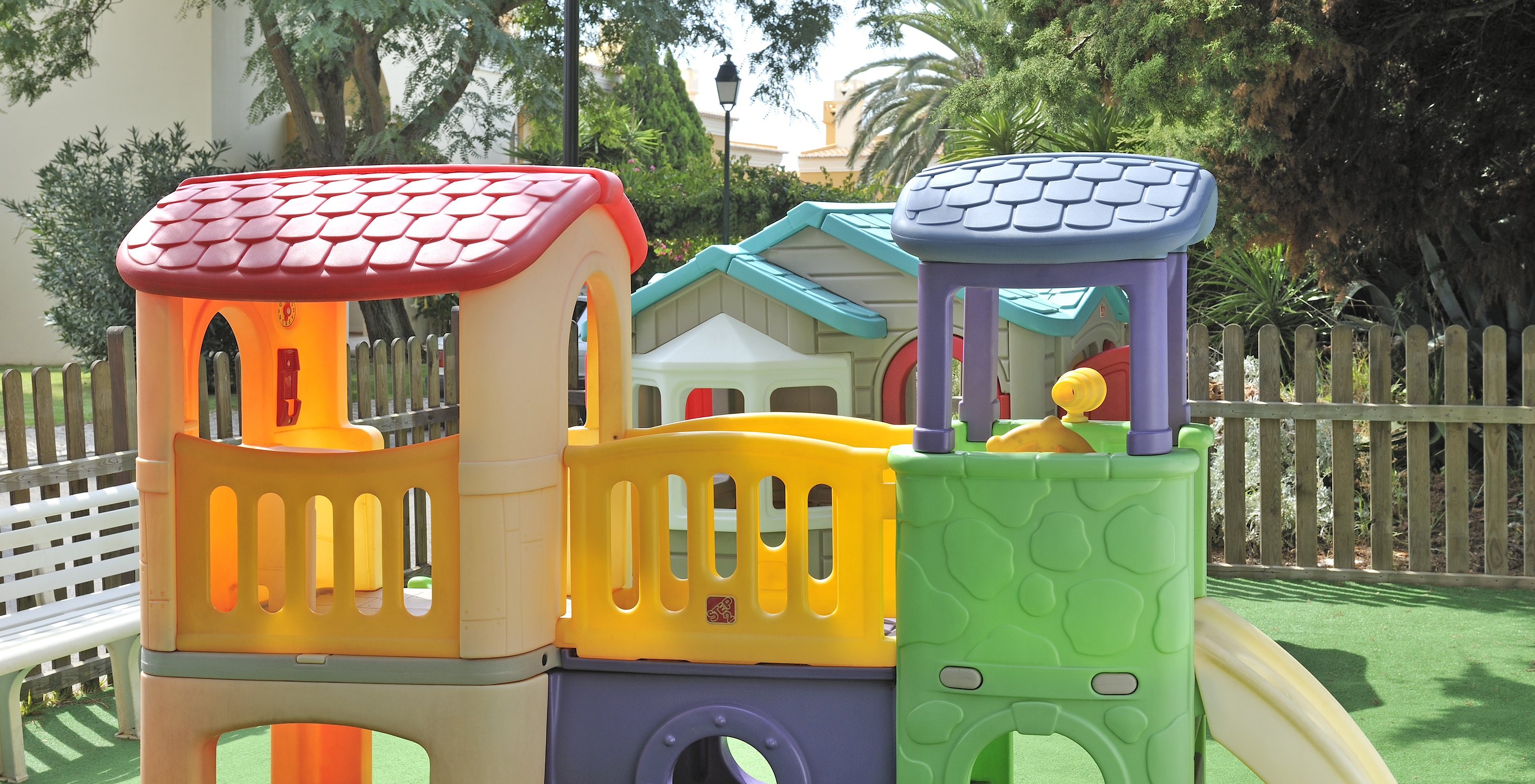 Spielplatz für Kinder, bunt mit verschiedenen Modulen und einer Rutsche auf der rechten Seite im Pestana Palm Gardens