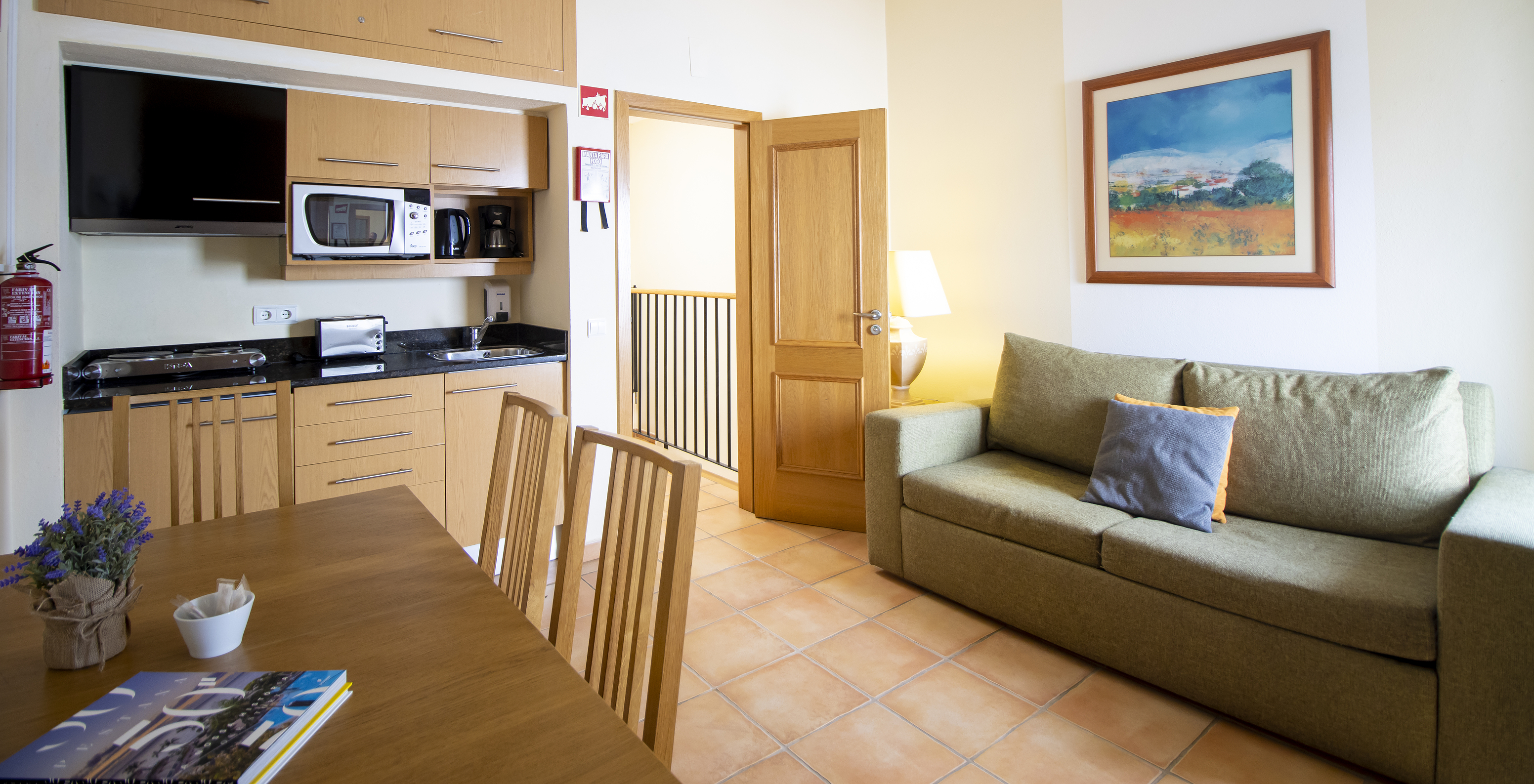 Das T1 Appartement - Terra im Pestana Palm Gardens hat ein Wohnzimmer mit Sofa, Tisch und Küchenzeile mit Mikrowelle