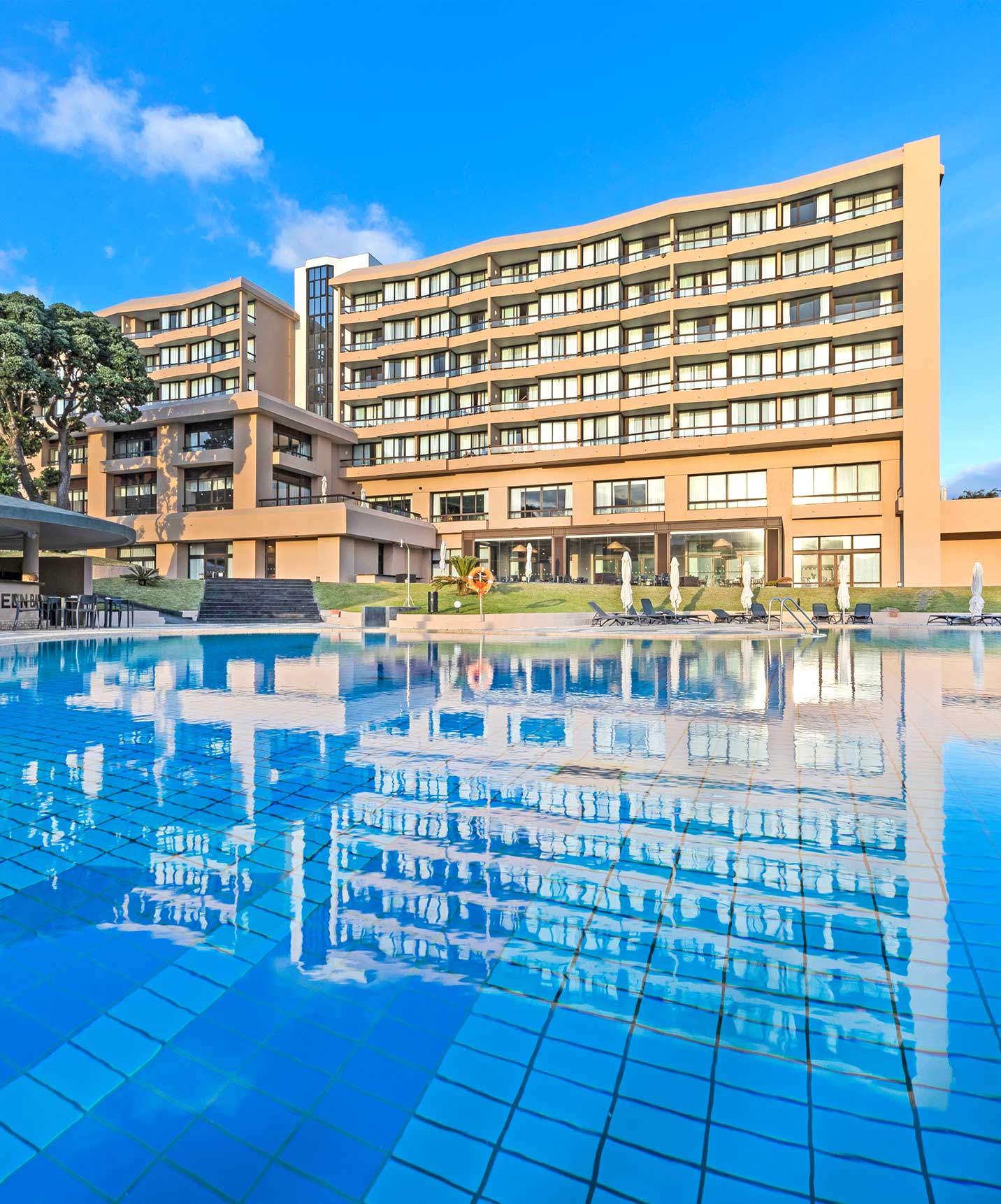 Außenpool im 4-Sterne-Hotel auf der Insel São Miguel, mit Blick auf Liegen und das Hauptgebäude