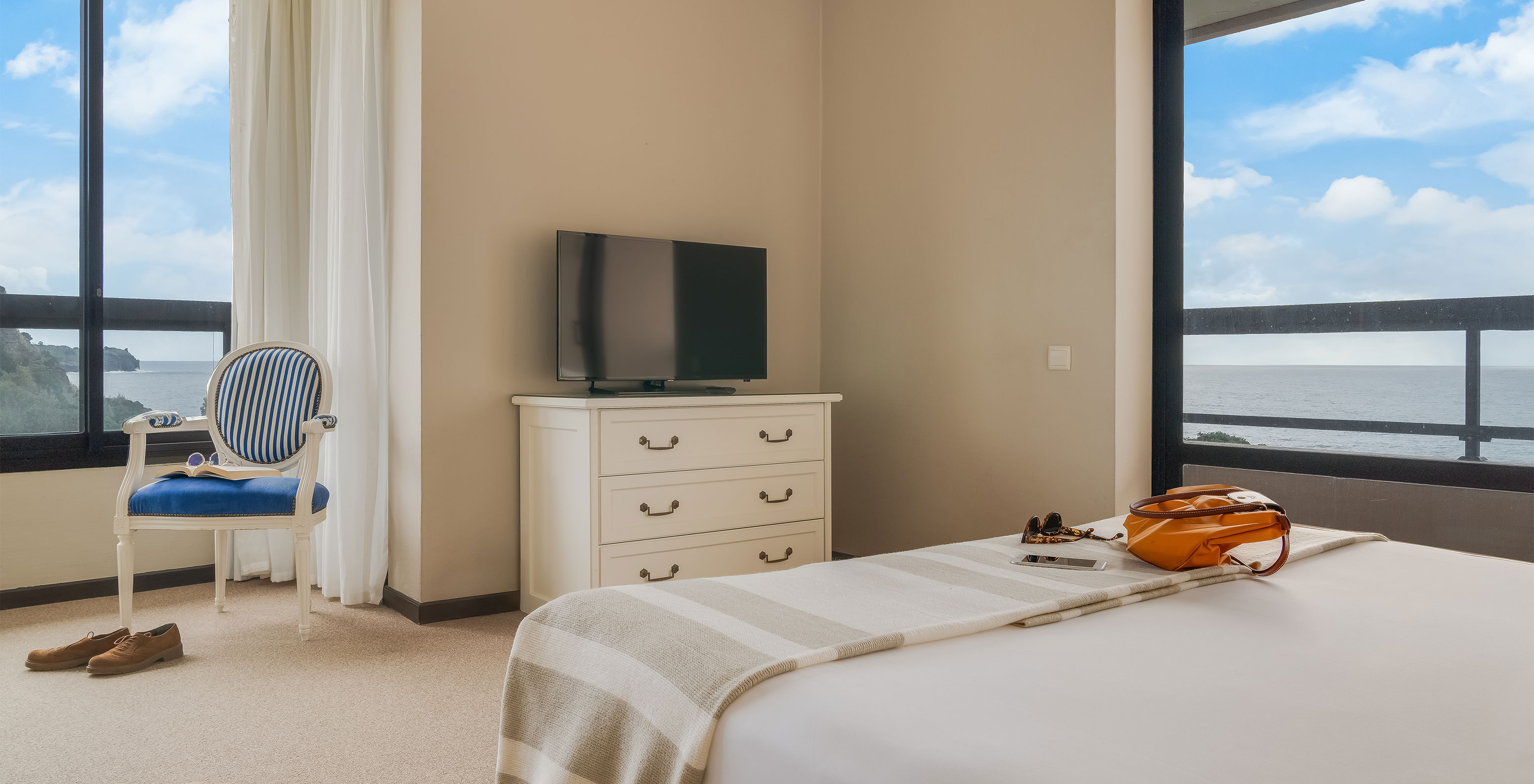 Das Standard Meerblick Zimmer im Pestana Bahia Praia hat zwei Fenster mit Meerblick und grüner Landschaft