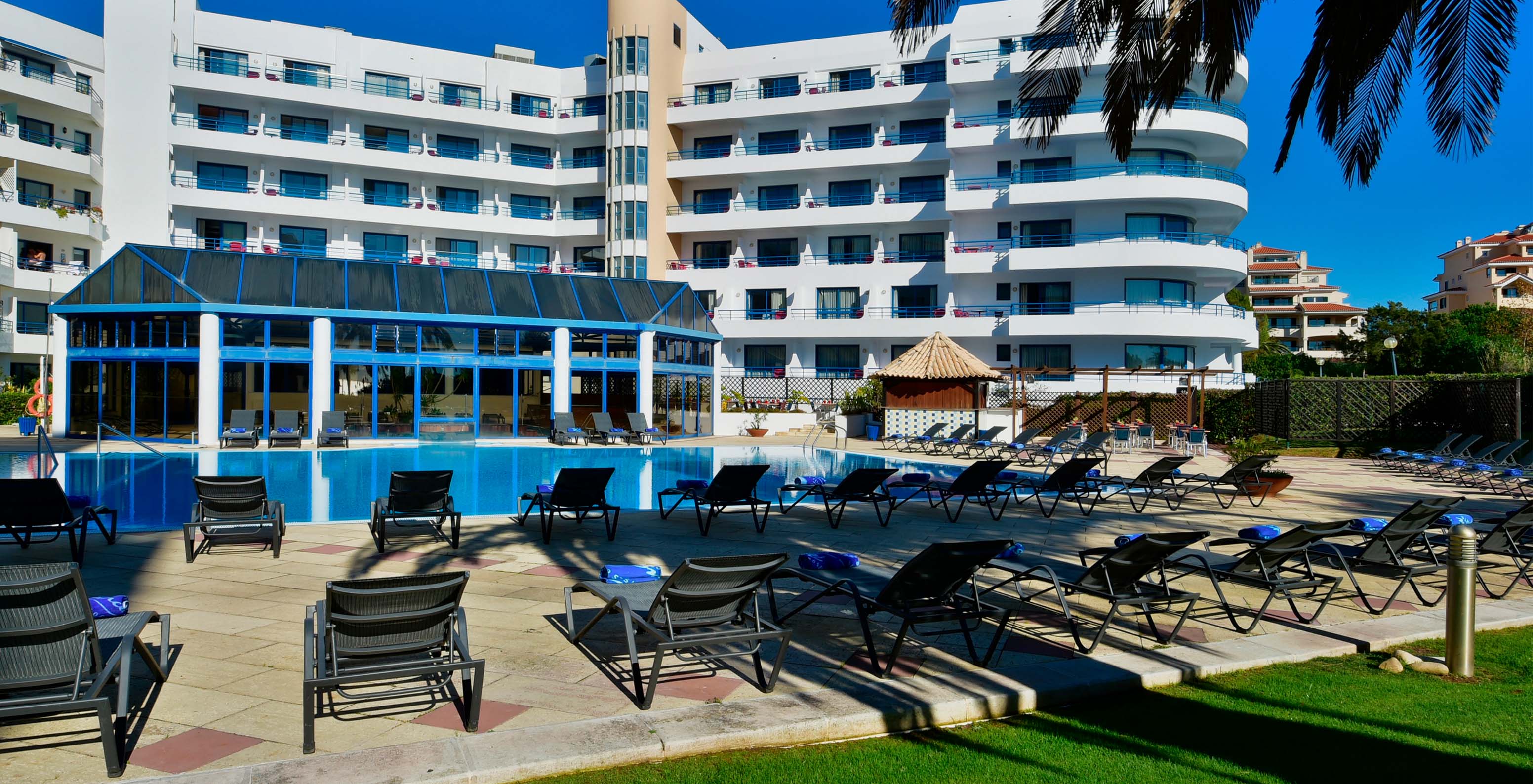 Blick auf den Garten des Pestana Cascais zum Außenpool, Liegen und der Poolbar