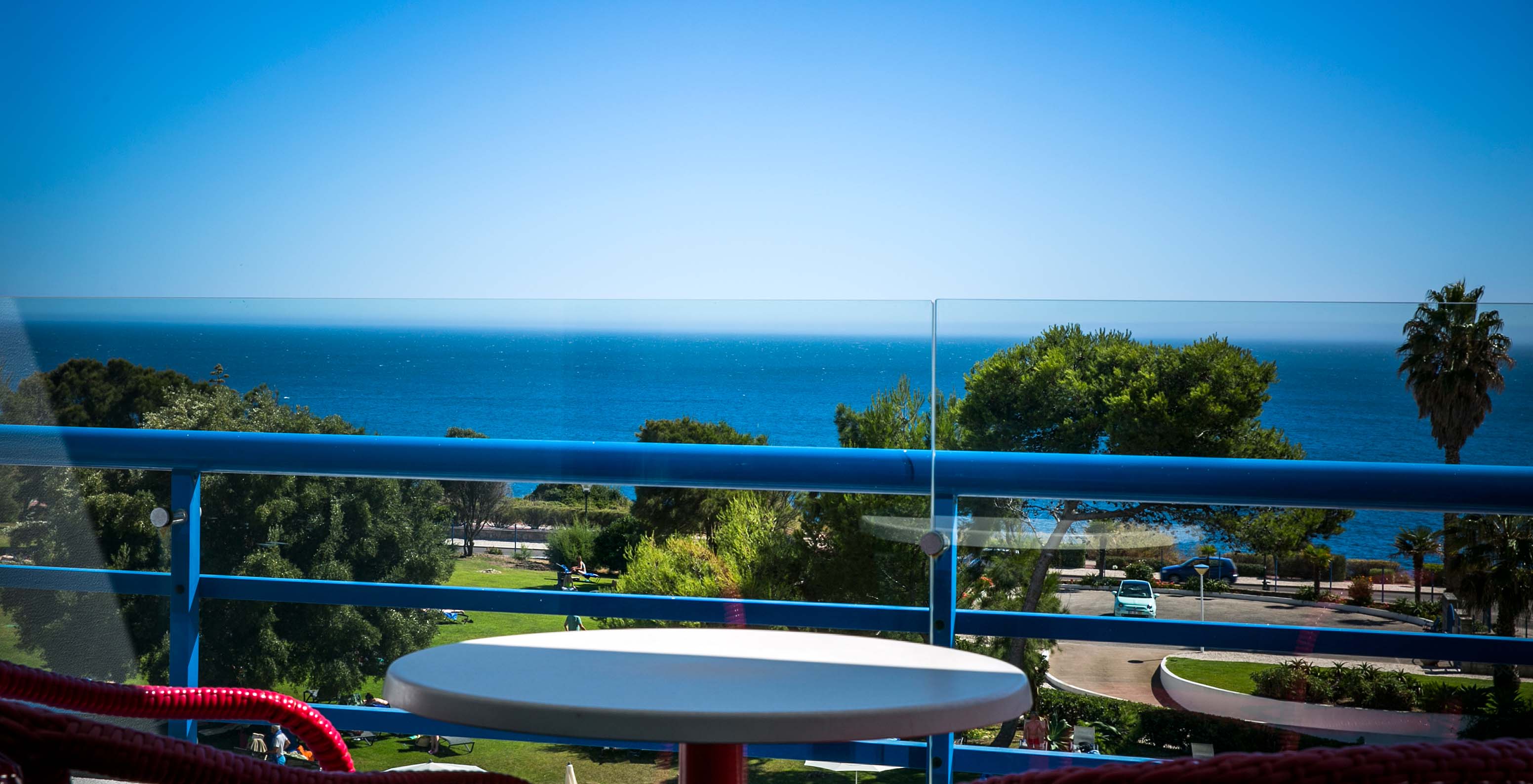 Das Deluxe-Zimmer mit Meerblick im Pestana Cascais hat einen Balkon mit Tisch und Stühlen mit Blick auf das Meer