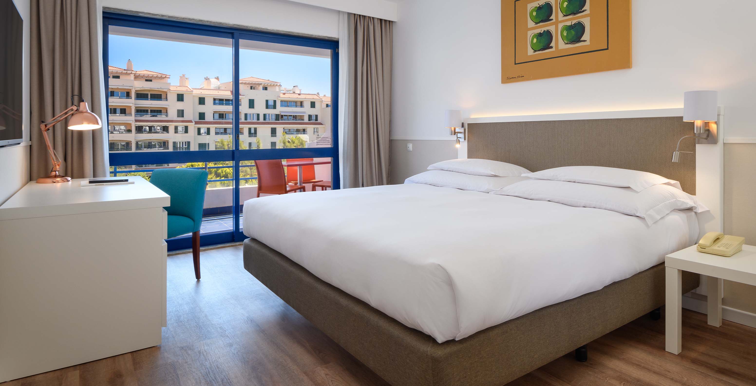 Die Deluxe Suite im Pestana Cascais hat ein Doppelbett, Schreibtisch und ein Bild an der Wand