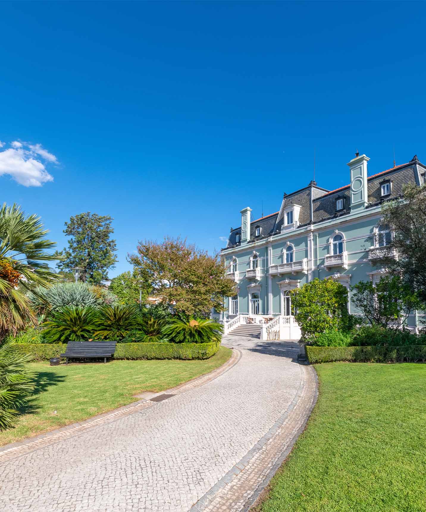 Gärten des Pestana Palace Lissabon mit Pools, gepflegtem Rasen und Palmen