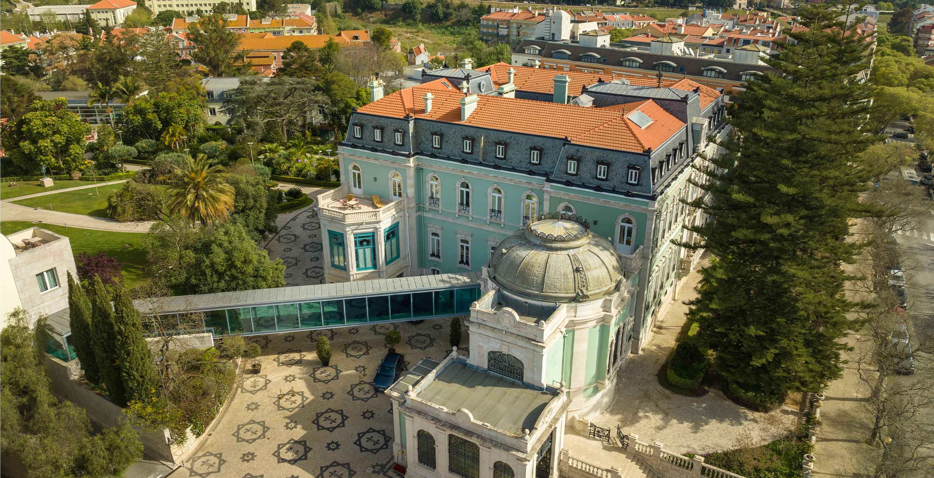 Luftaufnahme über das Hauptgebäude des Pestana Palace Lisboa, ein Hotel in einem Palast mit Pool, Spa und Gärten