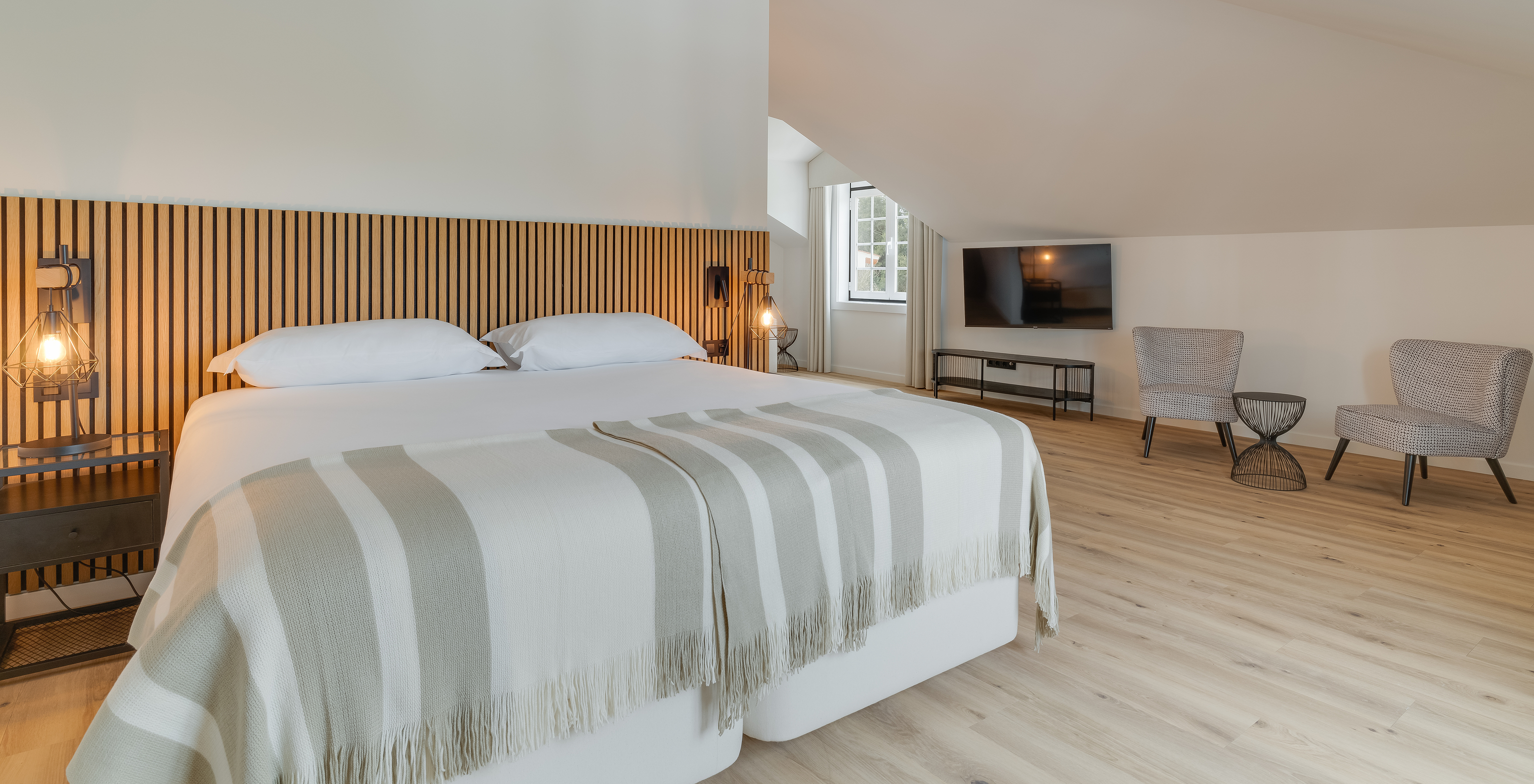 Die Suite im Clubhaus Pestana Sintra Golf hat ein Doppelbett mit Holz-Kopfteil und zwei Stühle