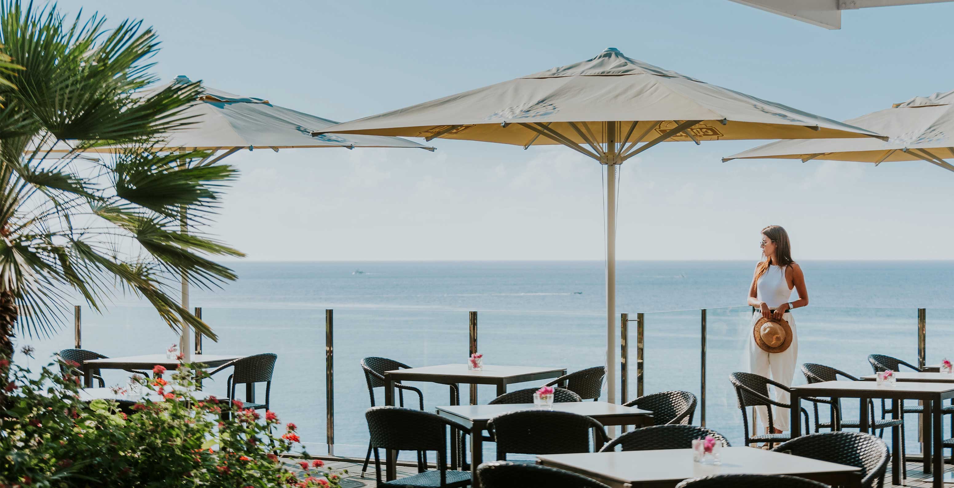 Das Pestana Carlton Madeira, ein Hotel im Zentrum von Funchal am Meer, hat eine Poolbar mit mehreren Tischen