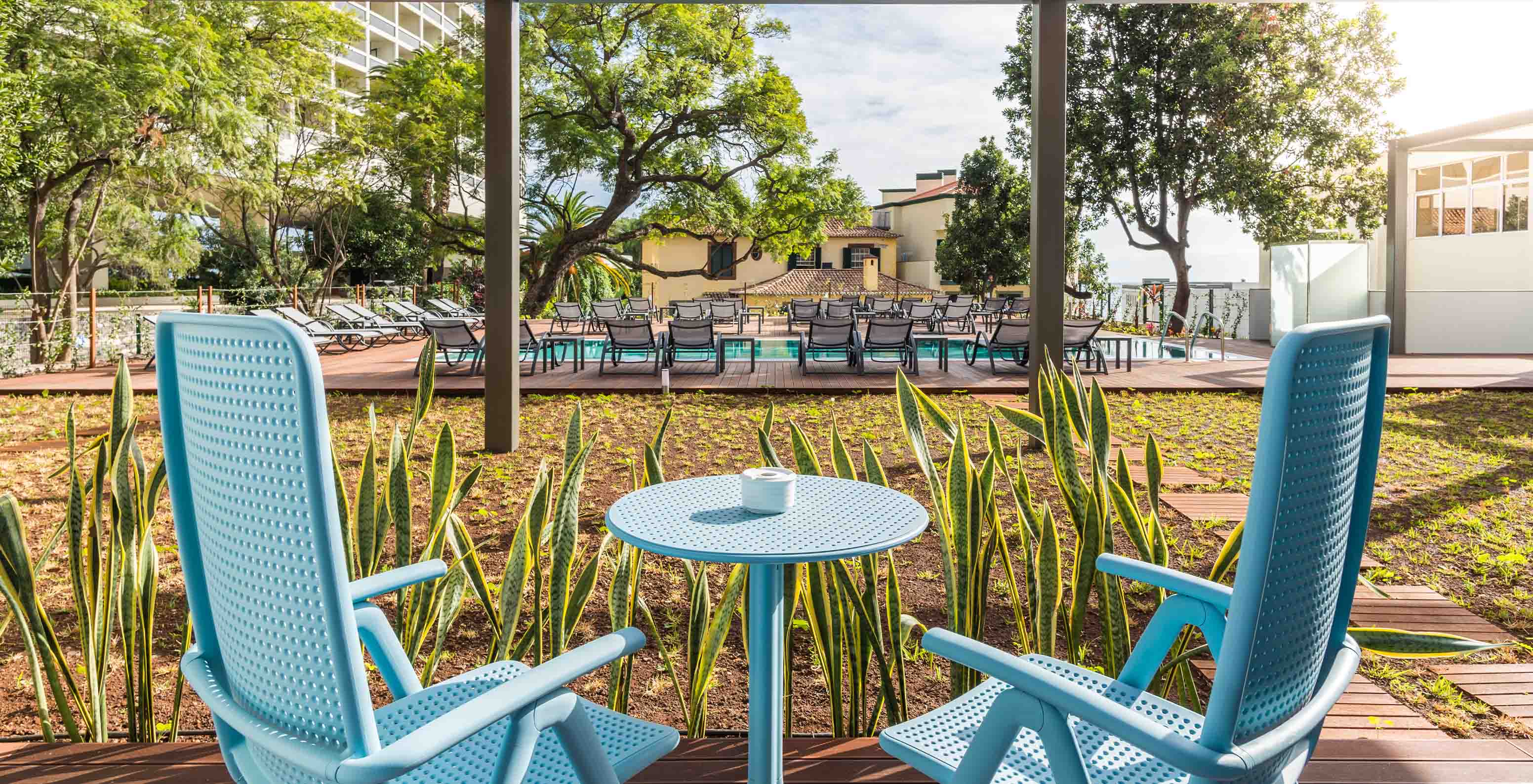 Die Pestana Casino Studios mit Apartments im Stadtzentrum mit Pool haben einen Tisch und Stühle mit Blick auf den Pool