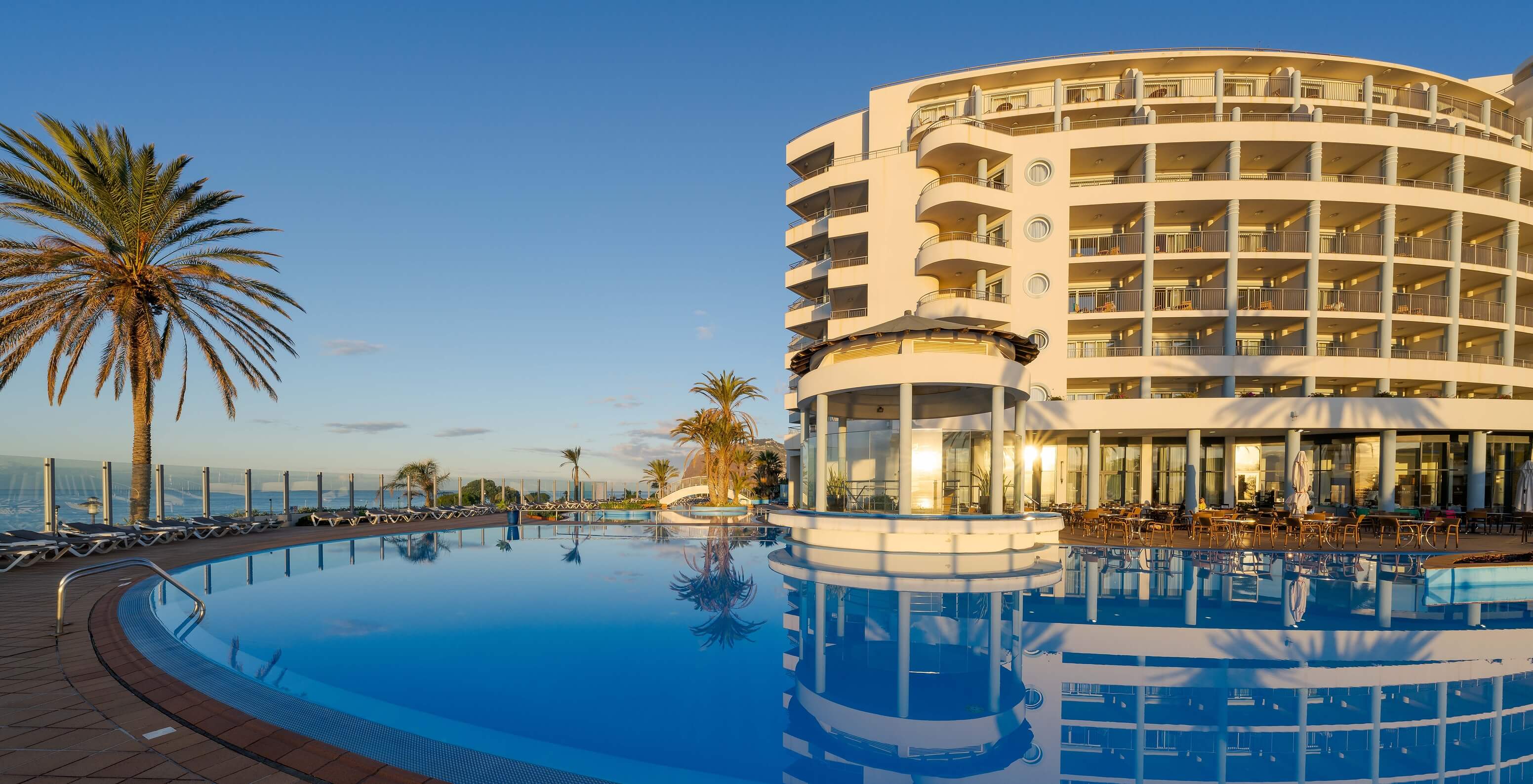 Außenpool des Pestana Grand, mit mehreren Liegestühlen und einer Terrasse, mit Blick auf den Ozean