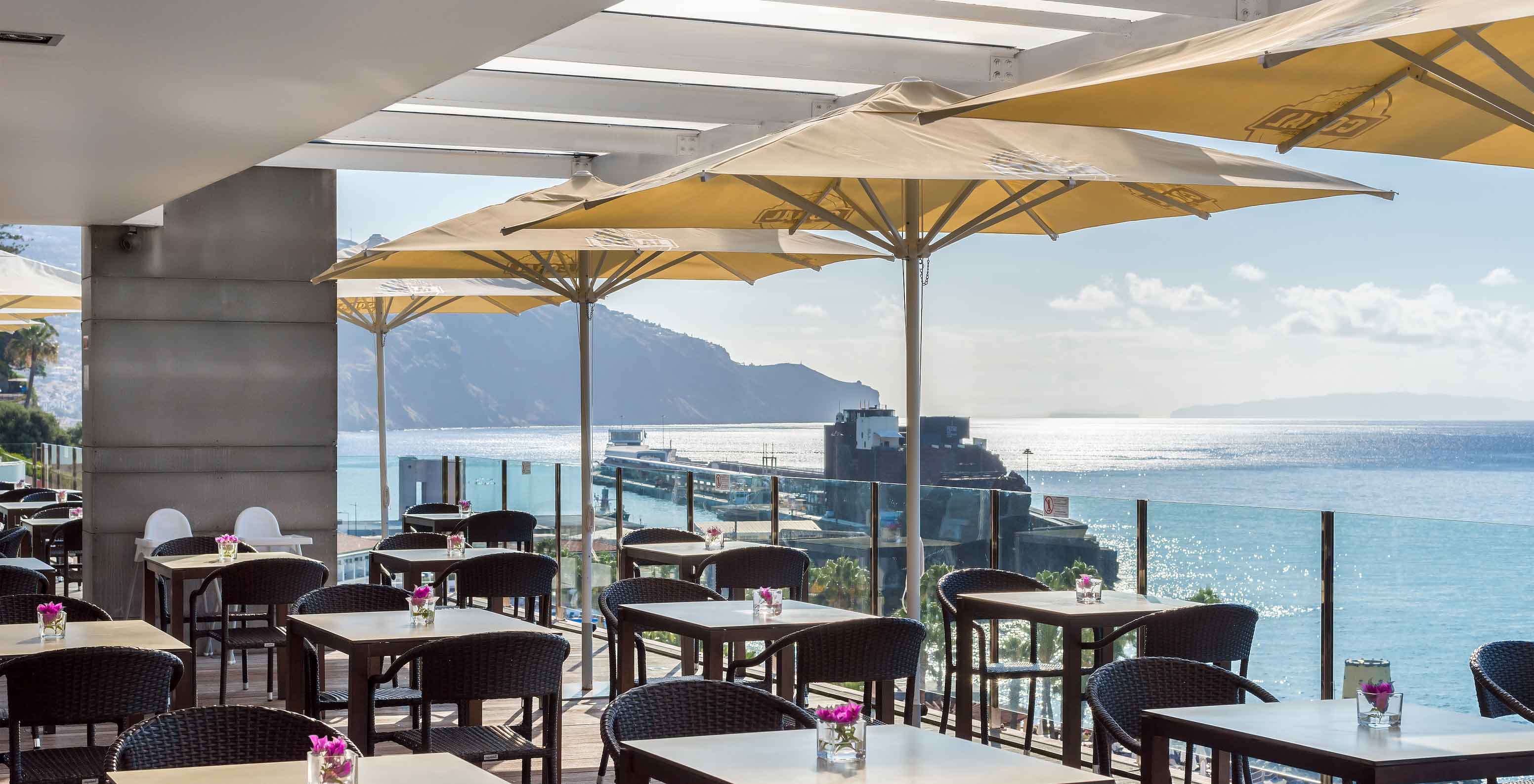 Die Poolbar, im Hotel im Zentrum von Funchal, Madeira, hat mehrere Tische mit Meerblick