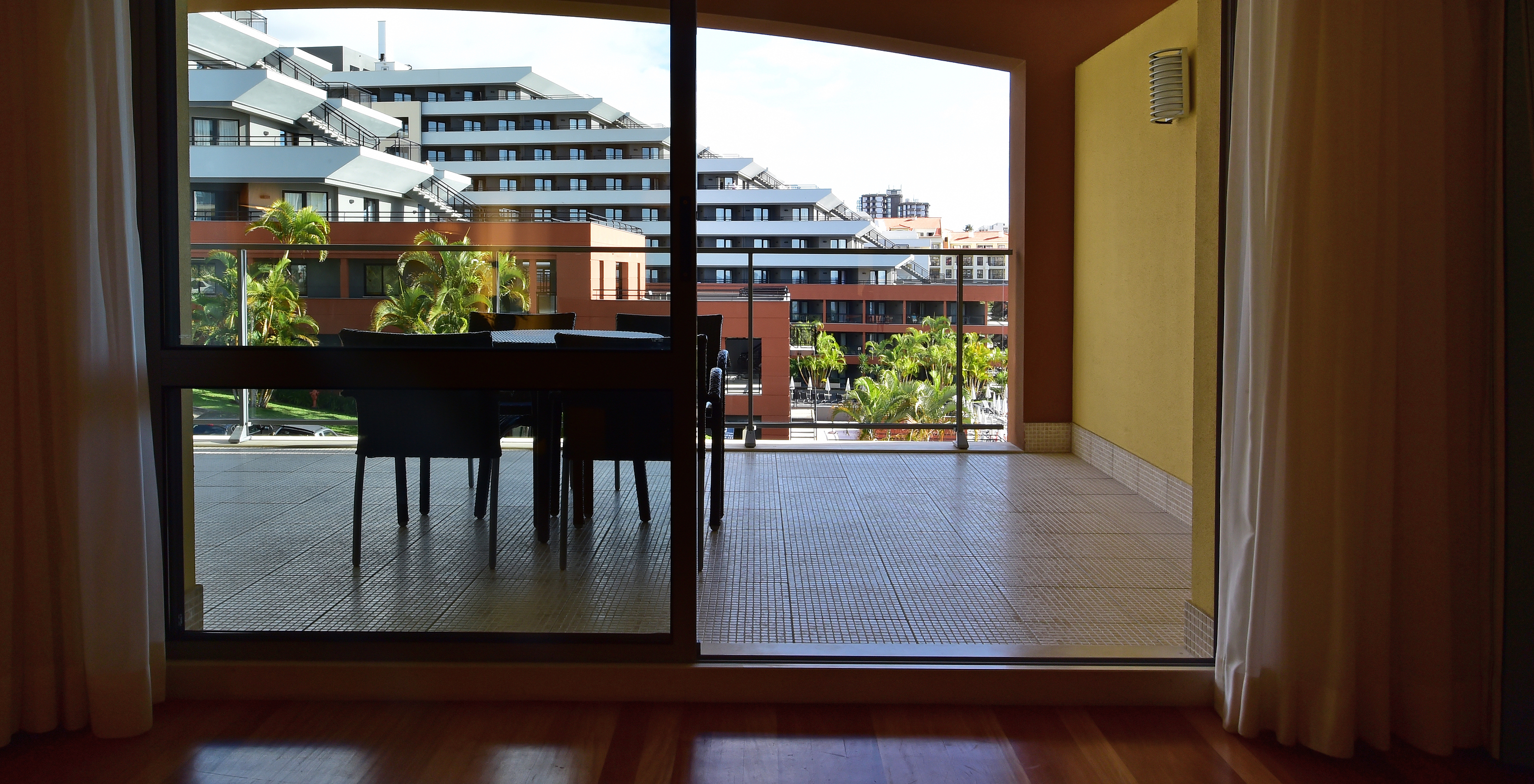 Das Klassik Zimmer hat einen geräumigen Balkon mit Esstisch und Blick auf andere Zimmer 