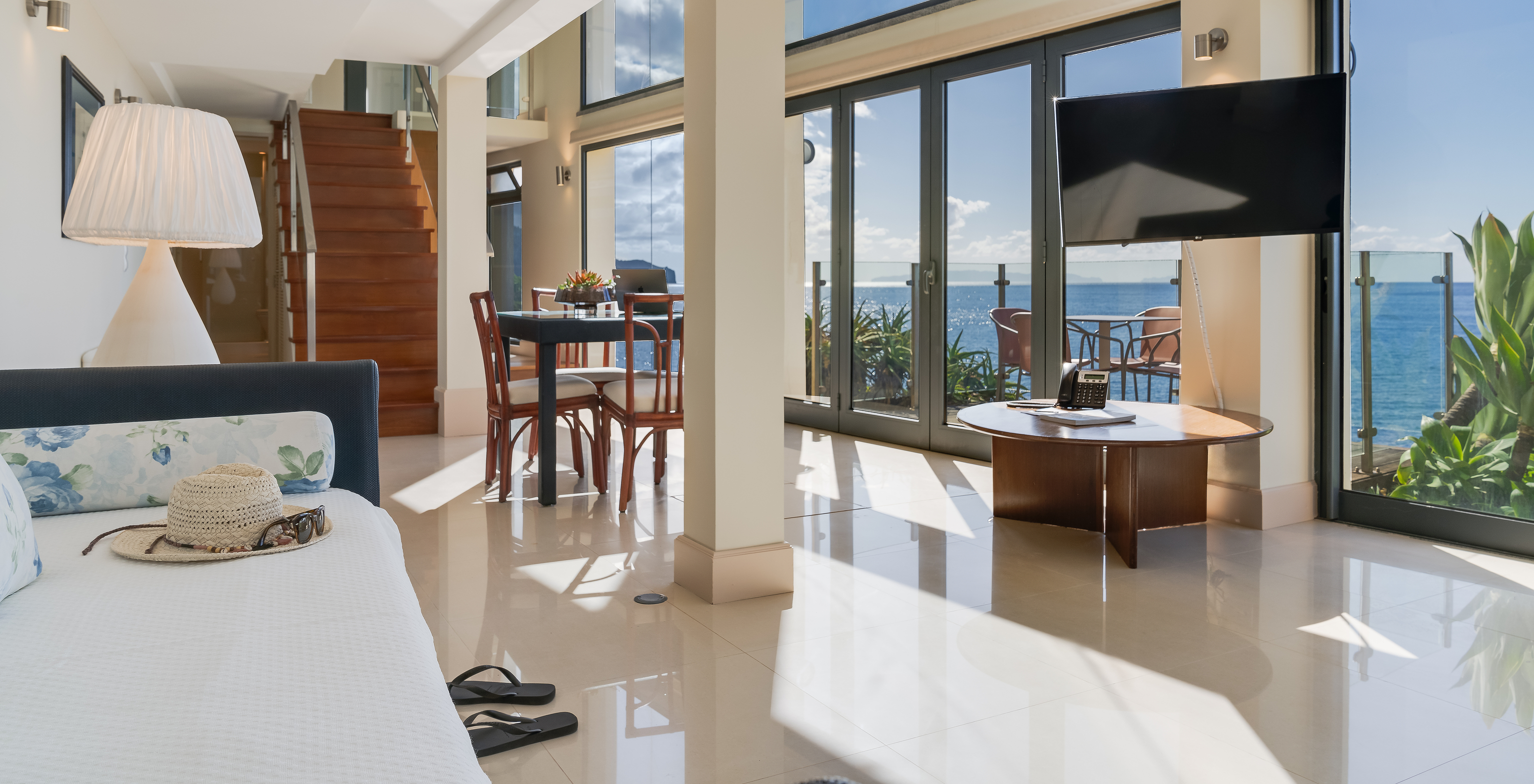 Suite Duplex Meerblick Pestana Vila Lido Madeira hat ein großes Wohnzimmer mit Meerblick, Sofa und Esszimmer