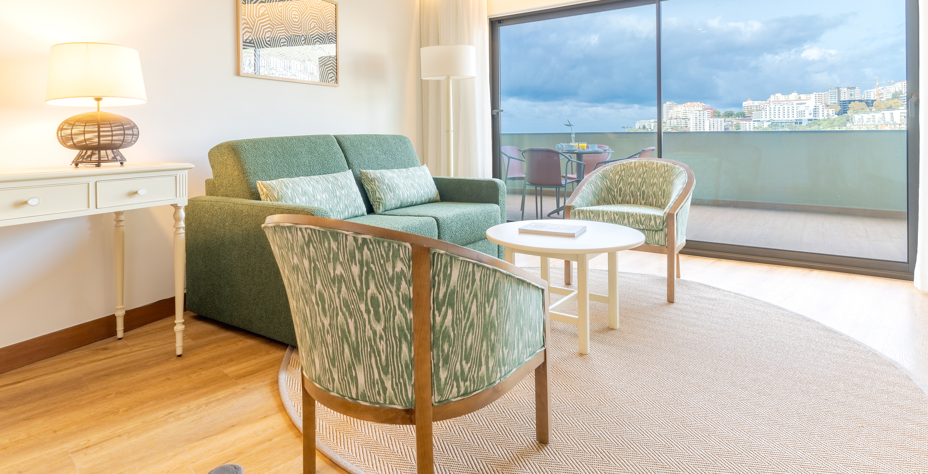 Suite Superior seitlicher Meerblick Pestana Vila Lido Madeira hat ein Wohnzimmer mit Sofa, Sesseln und Balkon