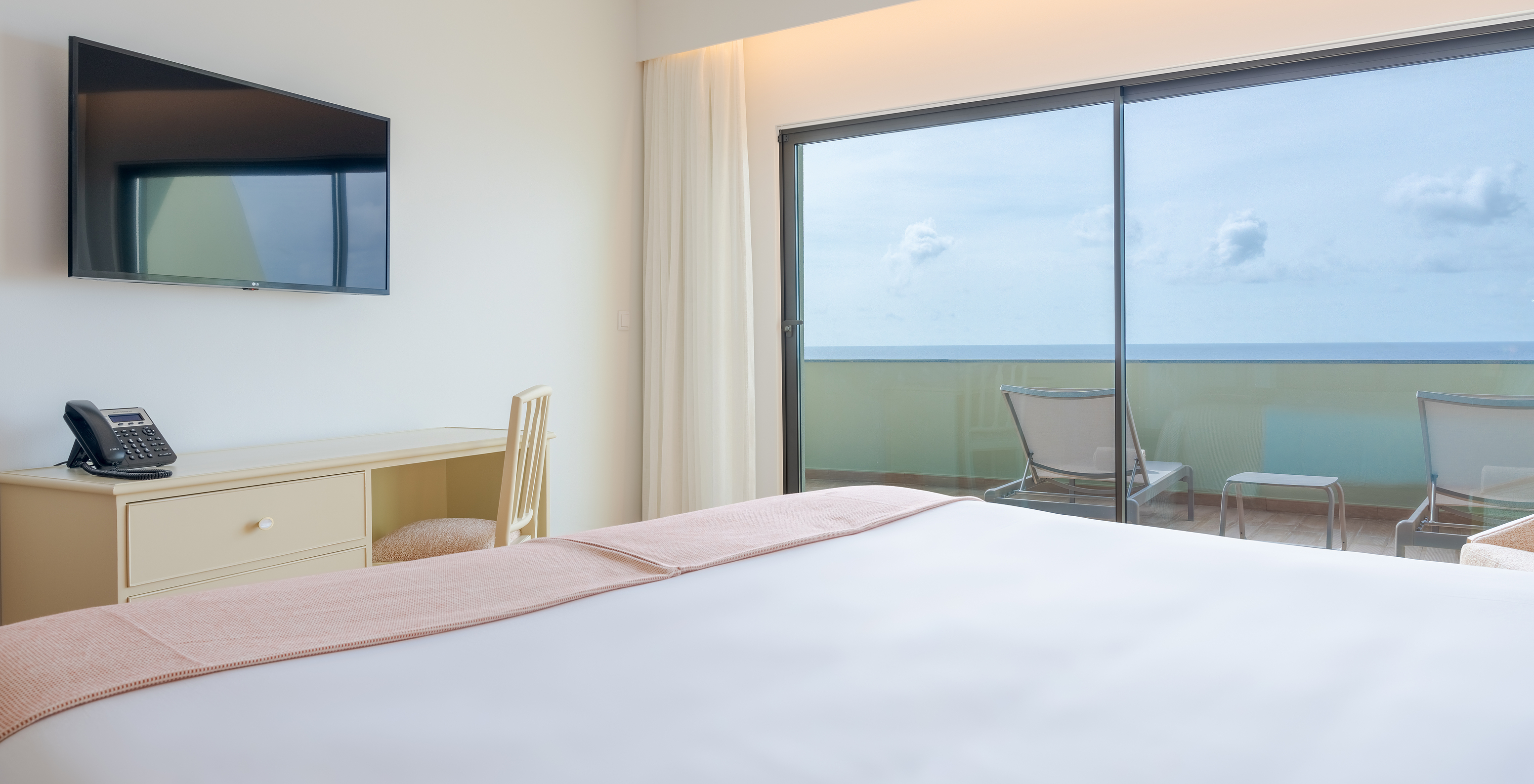 Suite Superior Meerblick Pestana Vila Lido Madeira hat ein Doppelbett mit Fernseher und Schreibtisch