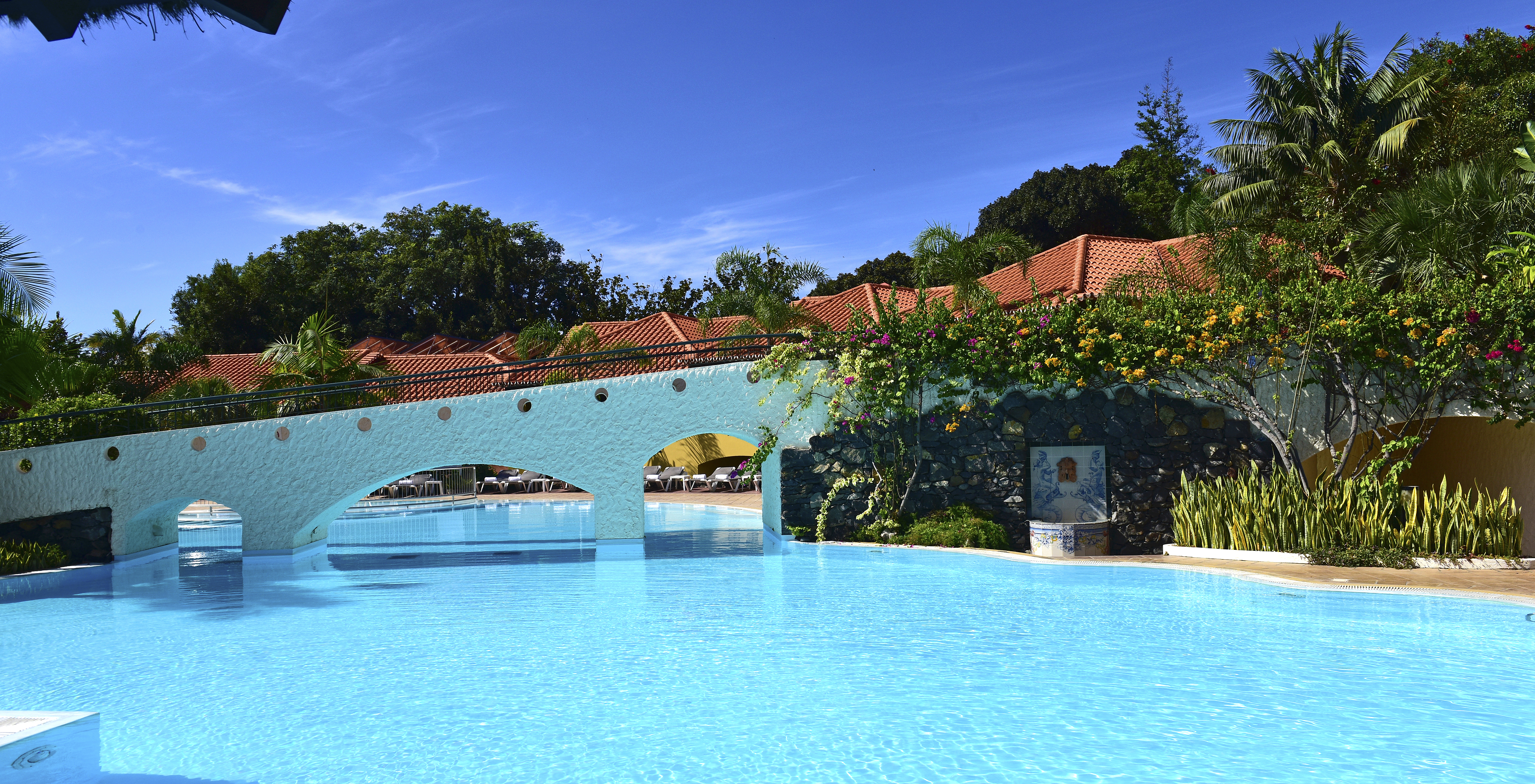 Pool des Pestana Village, einem romantischen Hotel in Funchal, Madeira, exklusiv für Kinder, mit einer Brücke