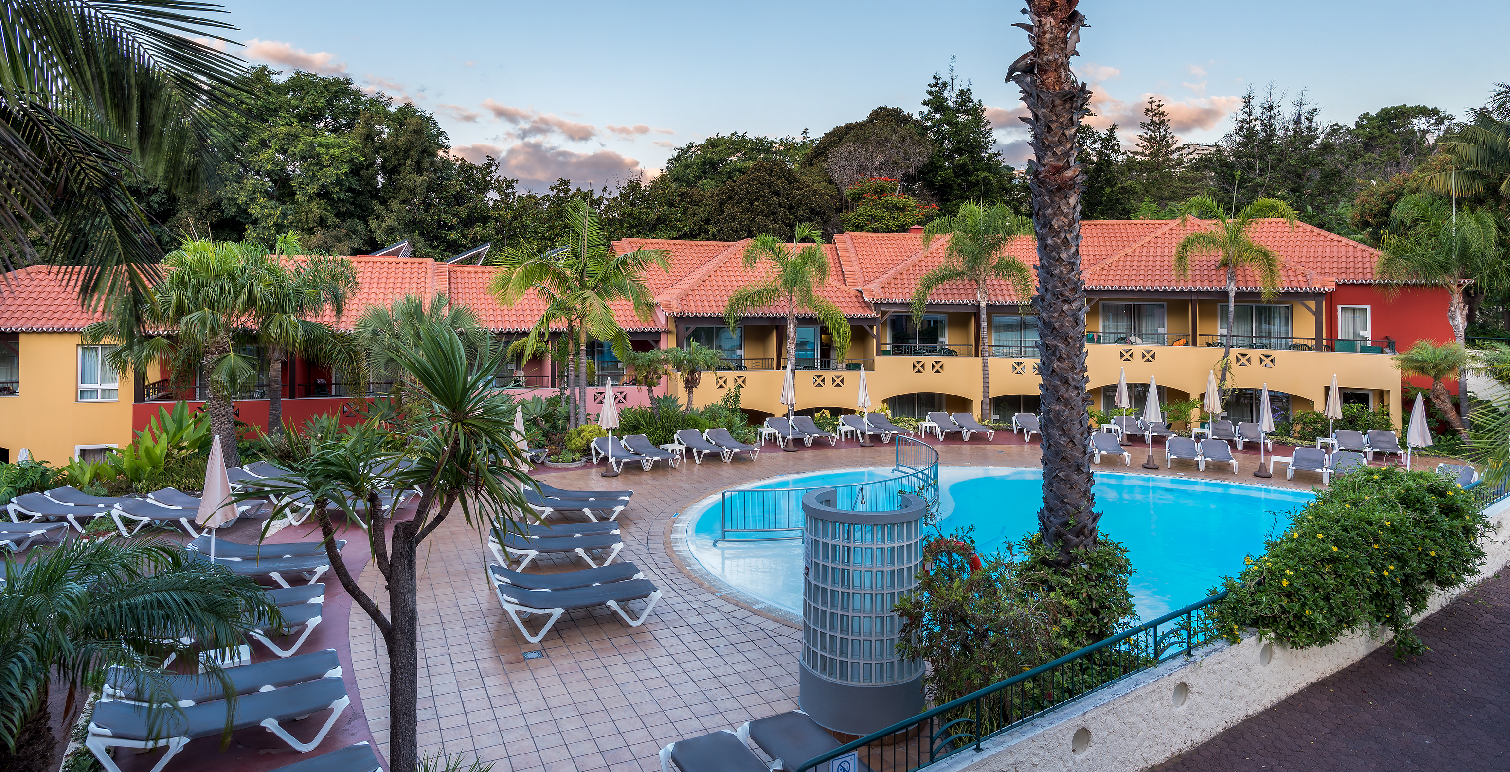 Außenbereich des Pestana Village, einem romantischen Hotel in Funchal, Madeira, mit seinem Pool und Liegen