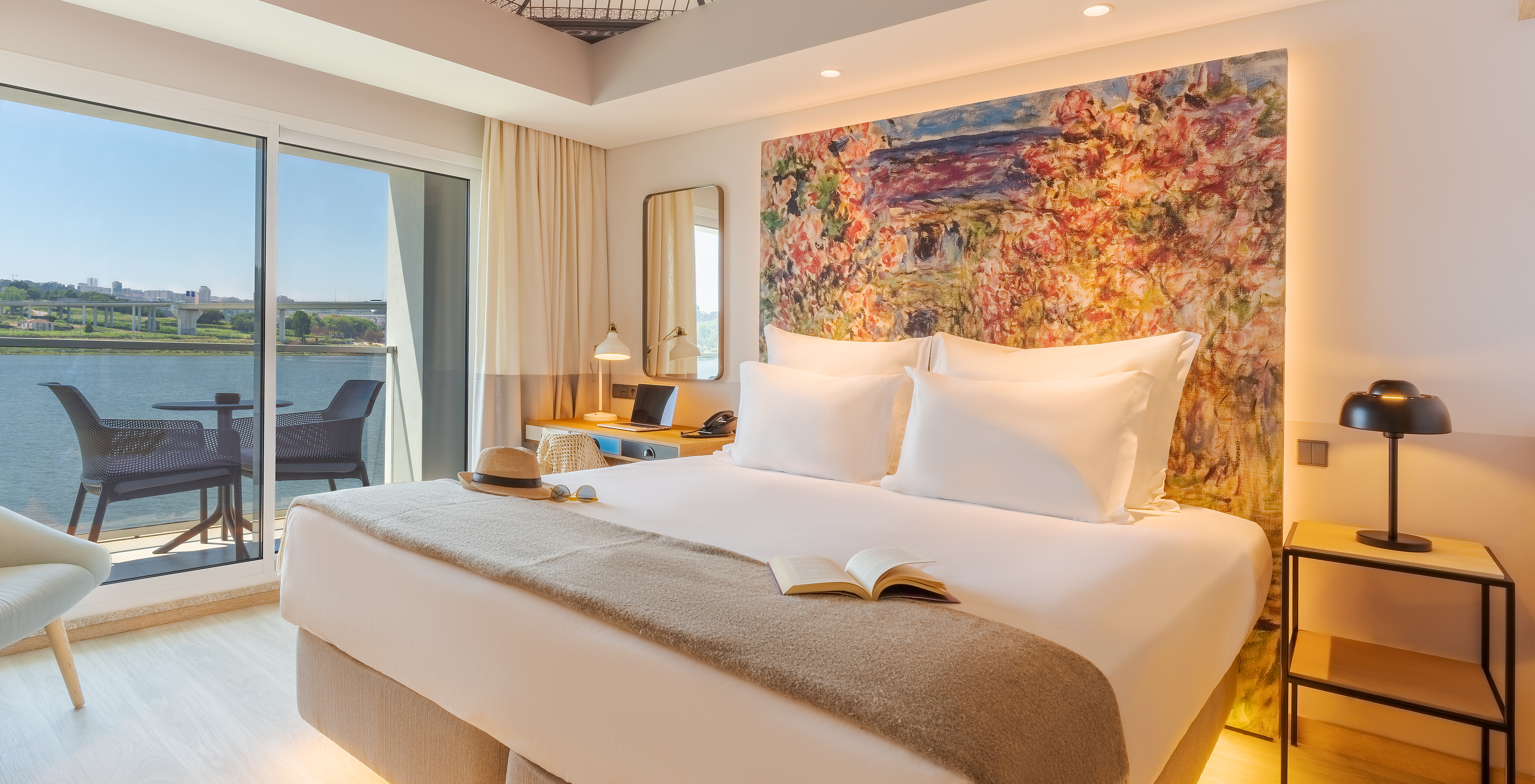 Das Deluxe River View Zimmer im Pestana Douro Riverside hat ein Doppelbett, Nachttisch und Balkon