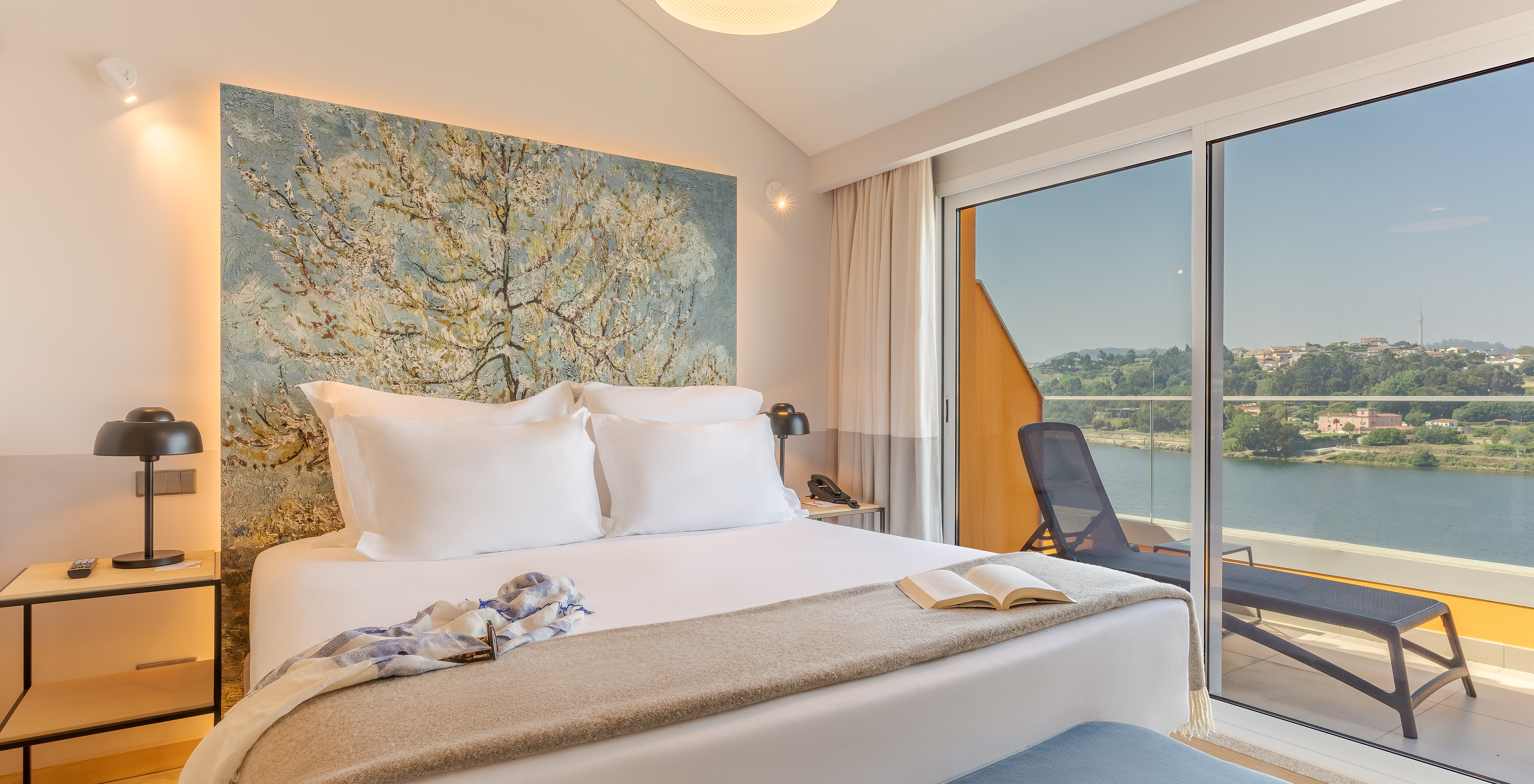 Die Suite im Pestana Douro Riverside hat ein Doppelbett, Balkon mit Blick, Nachttisch mit Lampe und Telefon