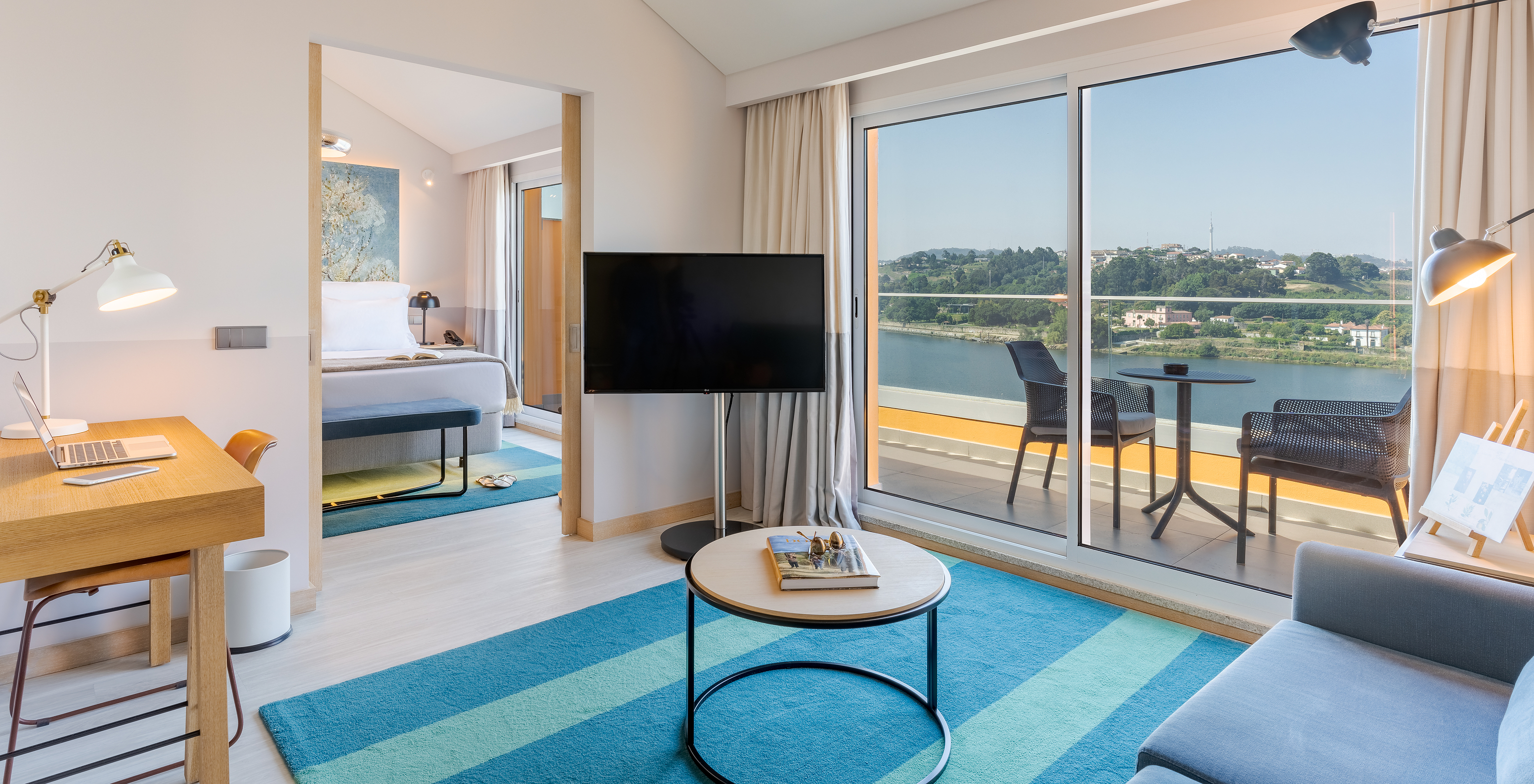 Die Suite im Pestana Douro Riverside hat Fernseher, Schreibtisch und Balkon mit Tisch und Stühlen