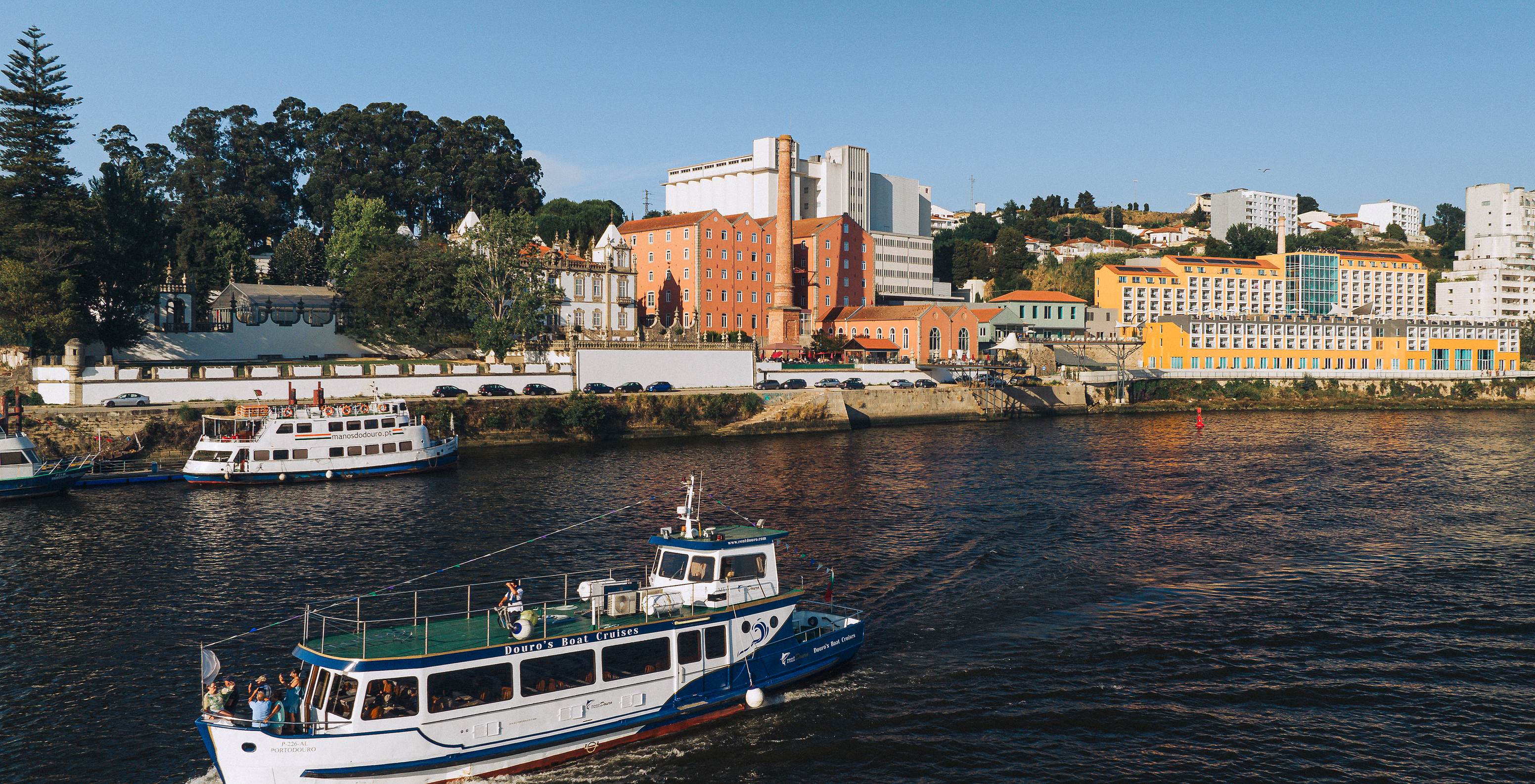 Blick auf den Fluss Douro zum Pestana Douro, wo ein Boot den Fluss befährt und das Hotel im Hintergrund sichtbar ist