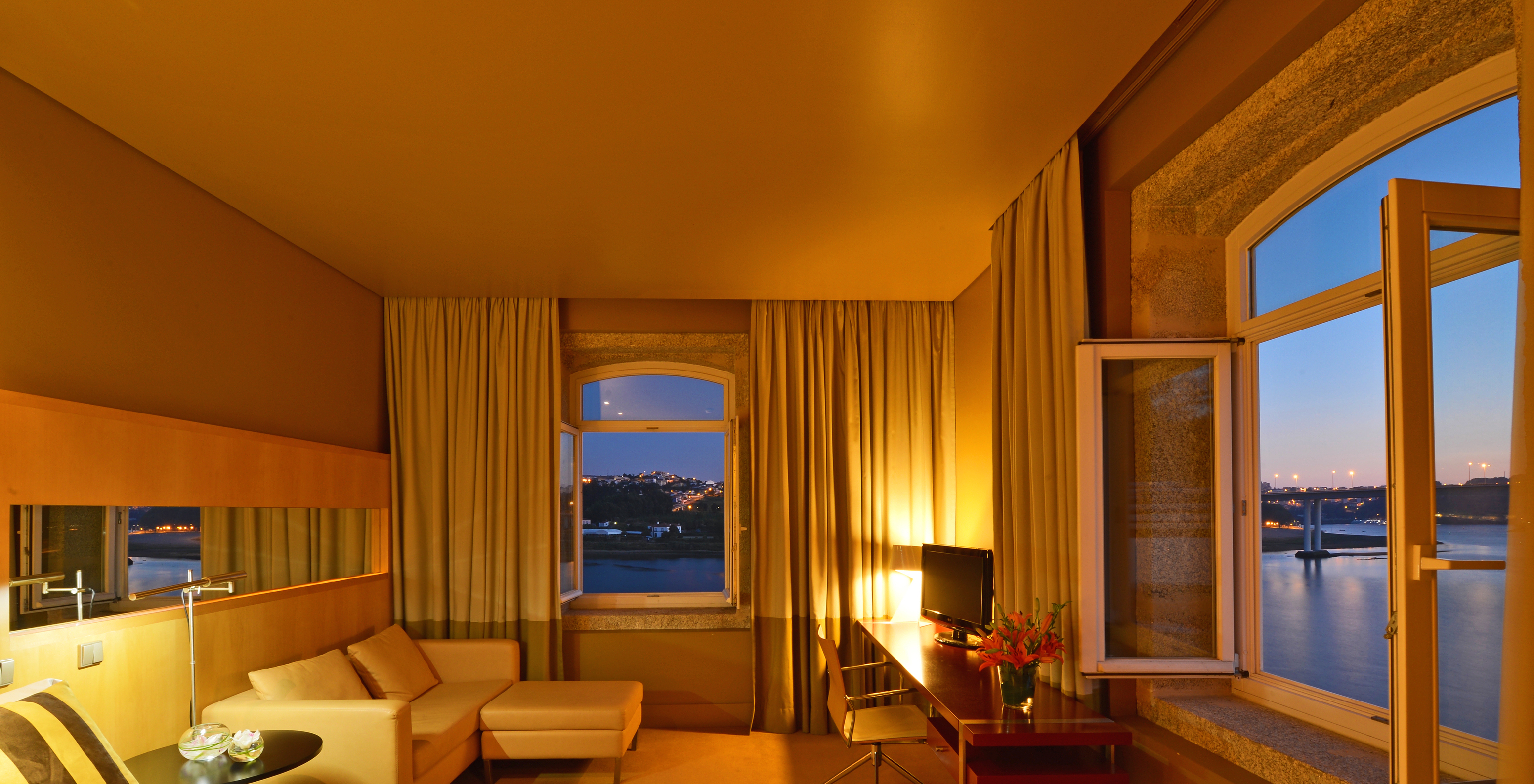 Das Deluxe Grand View Zimmer im Pestana Palácio do Freixo hat zwei Fenster mit Steinbrüstung und Flussblick