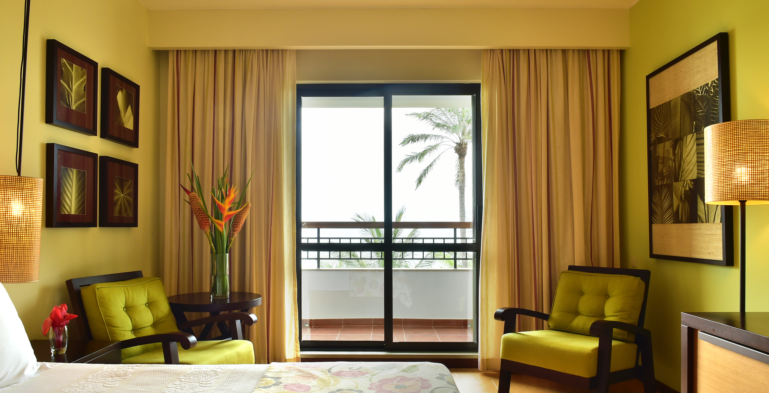 Das Meerblickzimmer im Pestana São Tomé hat einen Balkon mit Blick auf das Meer und Palmen