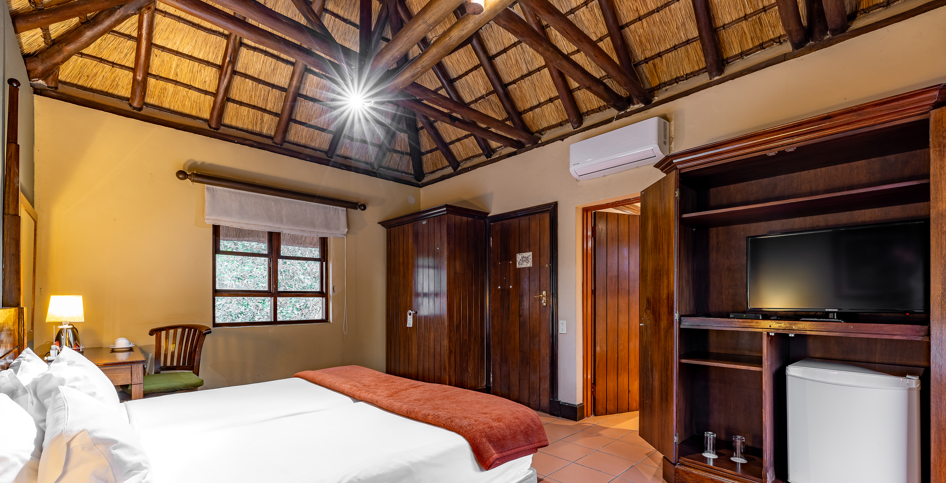 Das Standardzimmer im Pestana Kruger Lodge hat zwei Einzelbetten, Klimaanlage, Fernseher und Holzmobiliar