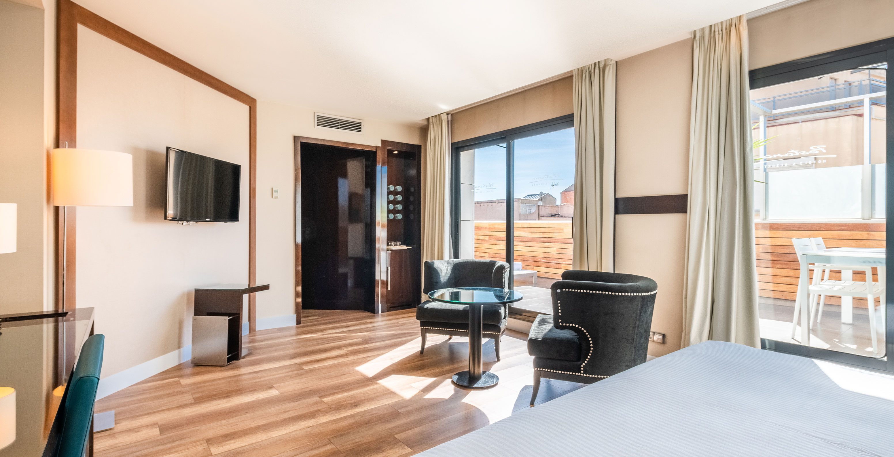 Die Junior Suite im Pestana Arena Barcelona hat einen Balkon mit Tisch und Stühlen und Blick auf die Stadt