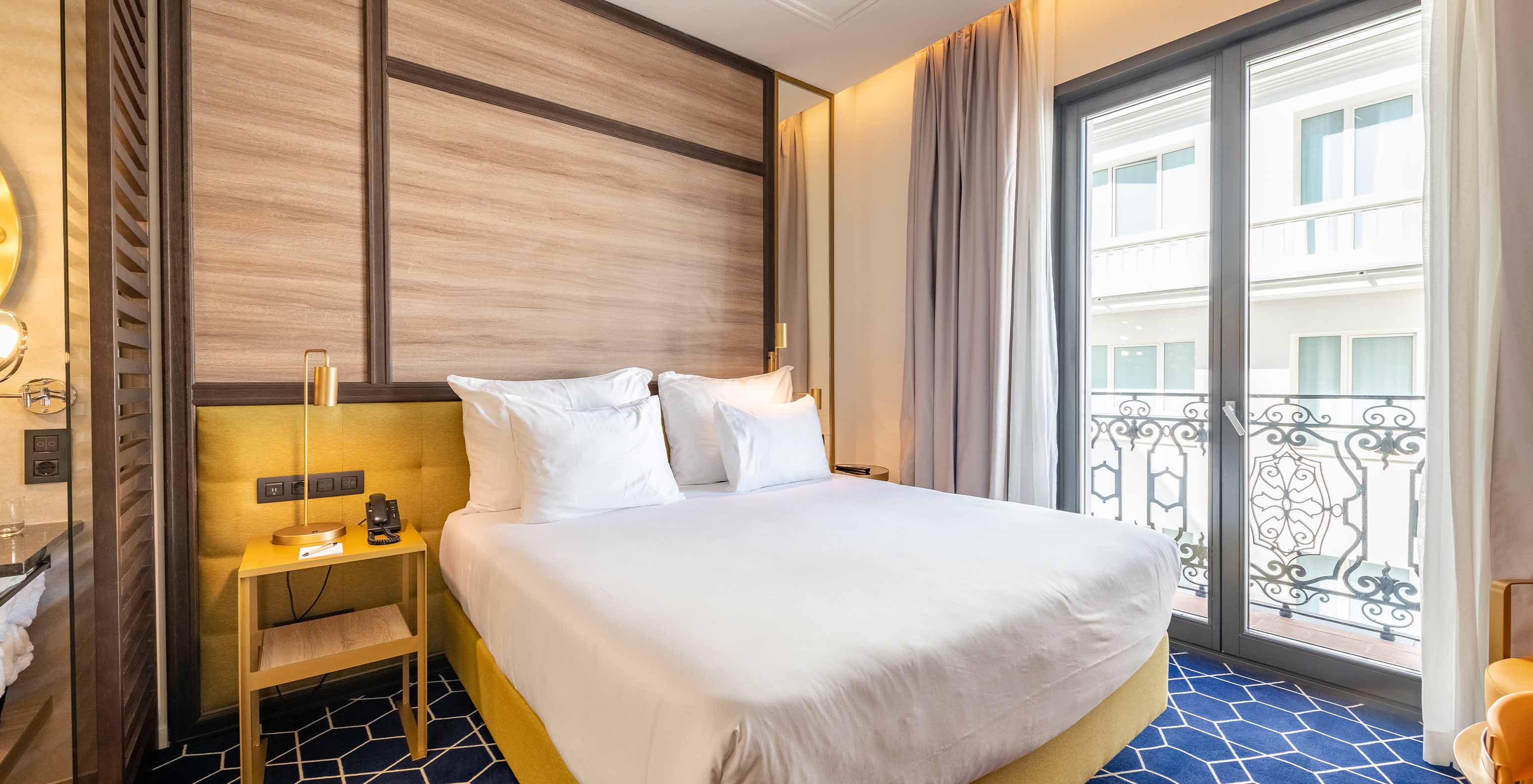 Der Premium Grand View Balkon im Pestana CR7 Gran Vía Madrid hat ein Doppelbett und große Fenster zum Gebäude