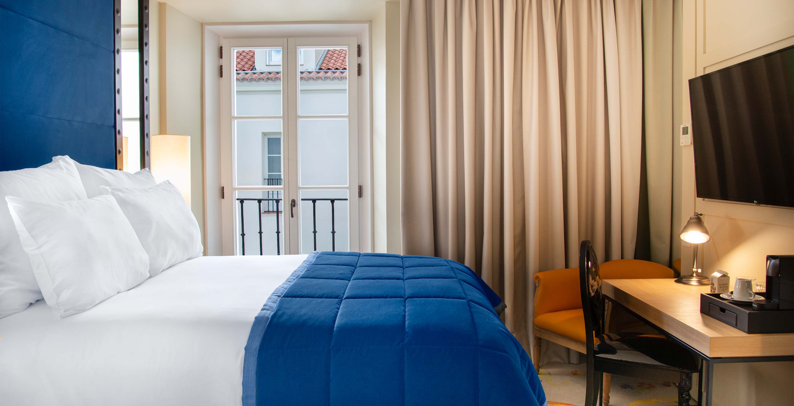 Das Klassische Zimmer im Pestana Plaza Mayor Madrid hat ein Doppelbett, Fernseher, Schreibtisch und ein Fenster