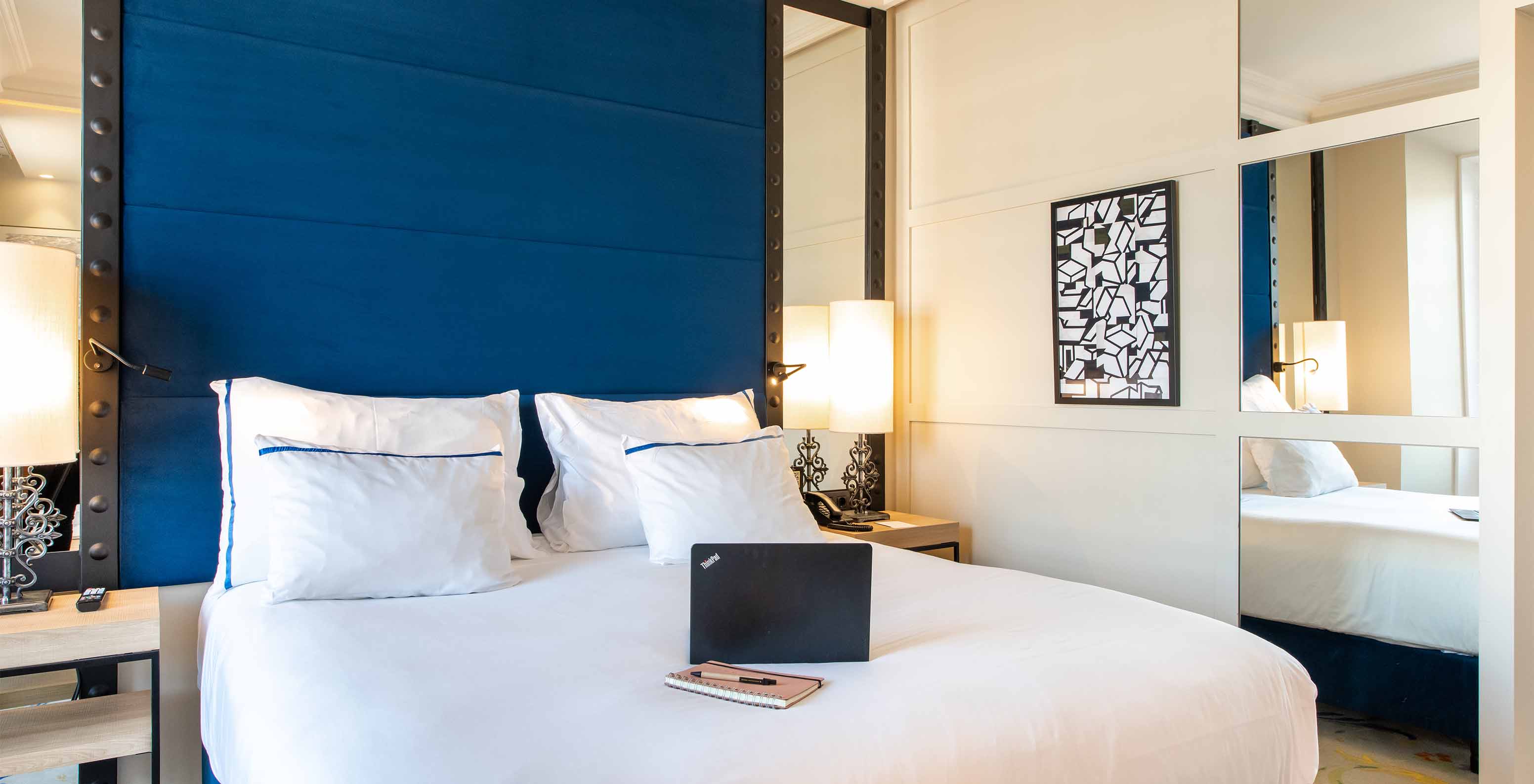 Das Deluxe Plaza Mayor im Pestana Plaza Mayor Madrid hat ein Doppelbett, zwei Nachttische und einen Spiegel an der Wand