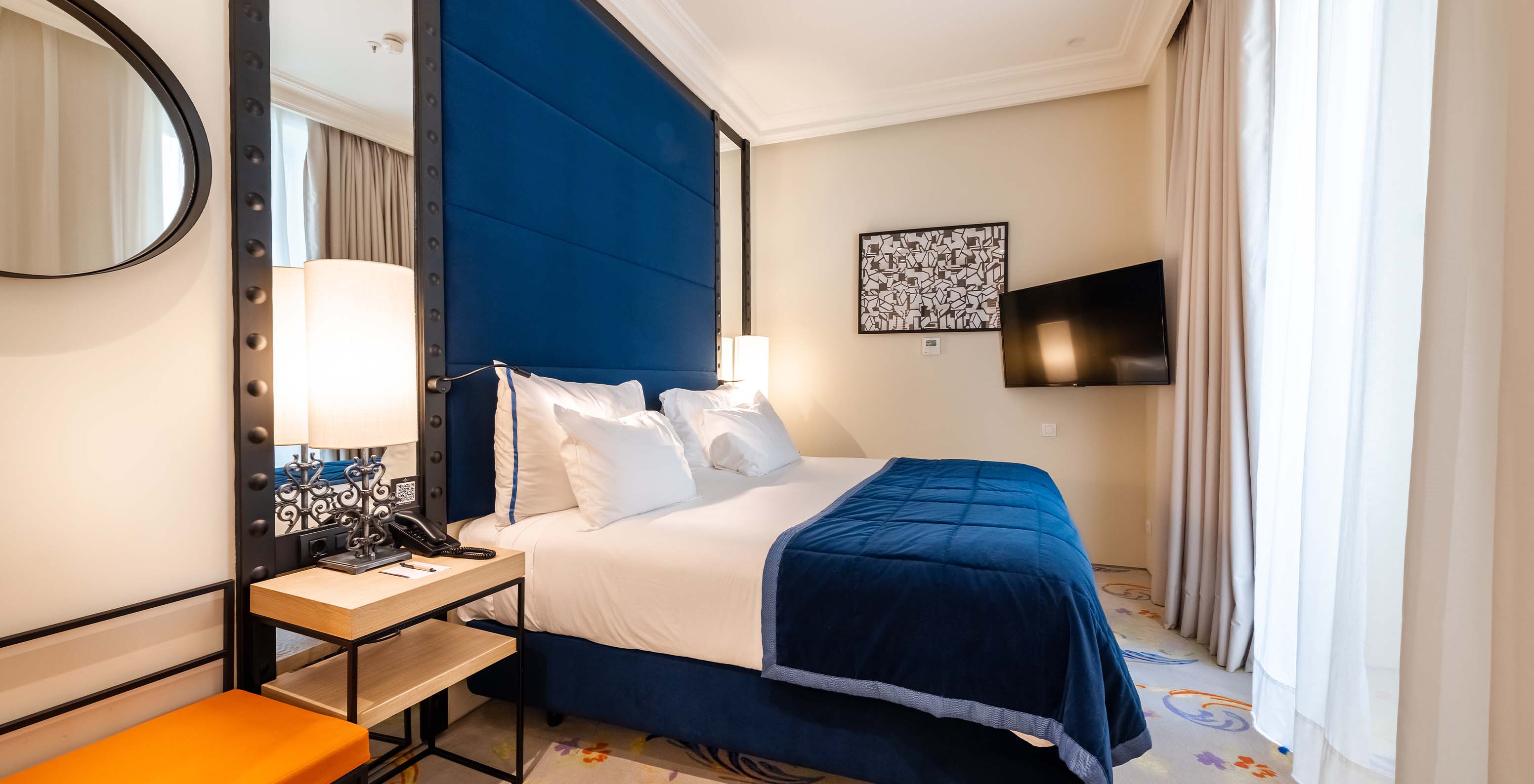 Die Suite im Pestana Plaza Mayor Madrid hat ein Doppelbett, Nachttisch, Fernseher an der Wand und ein Fenster