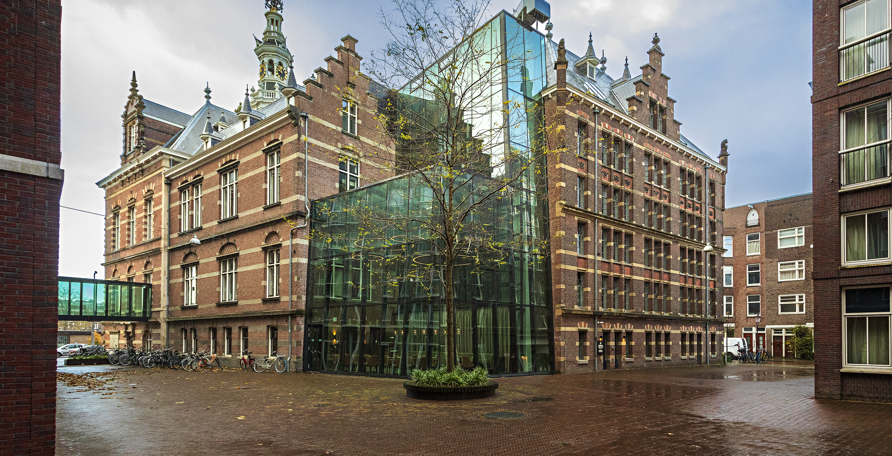 Außenansicht des Pestana Amsterdam Riverside, mit roter Backsteinfassade und modernem Glasanbau