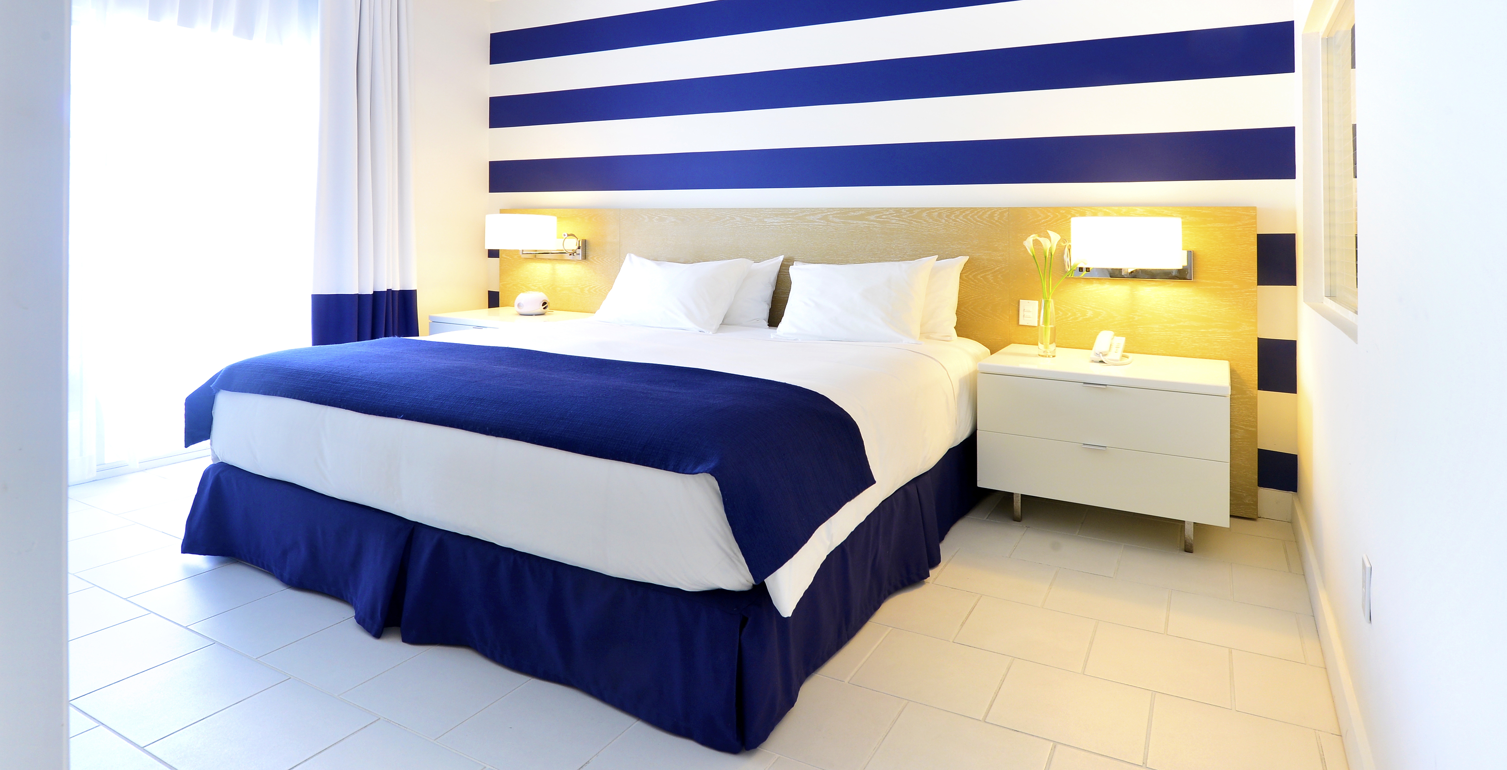 Die Suite im Pestana Miami South Beach hat Doppelbett, Nachttisch und Lampe