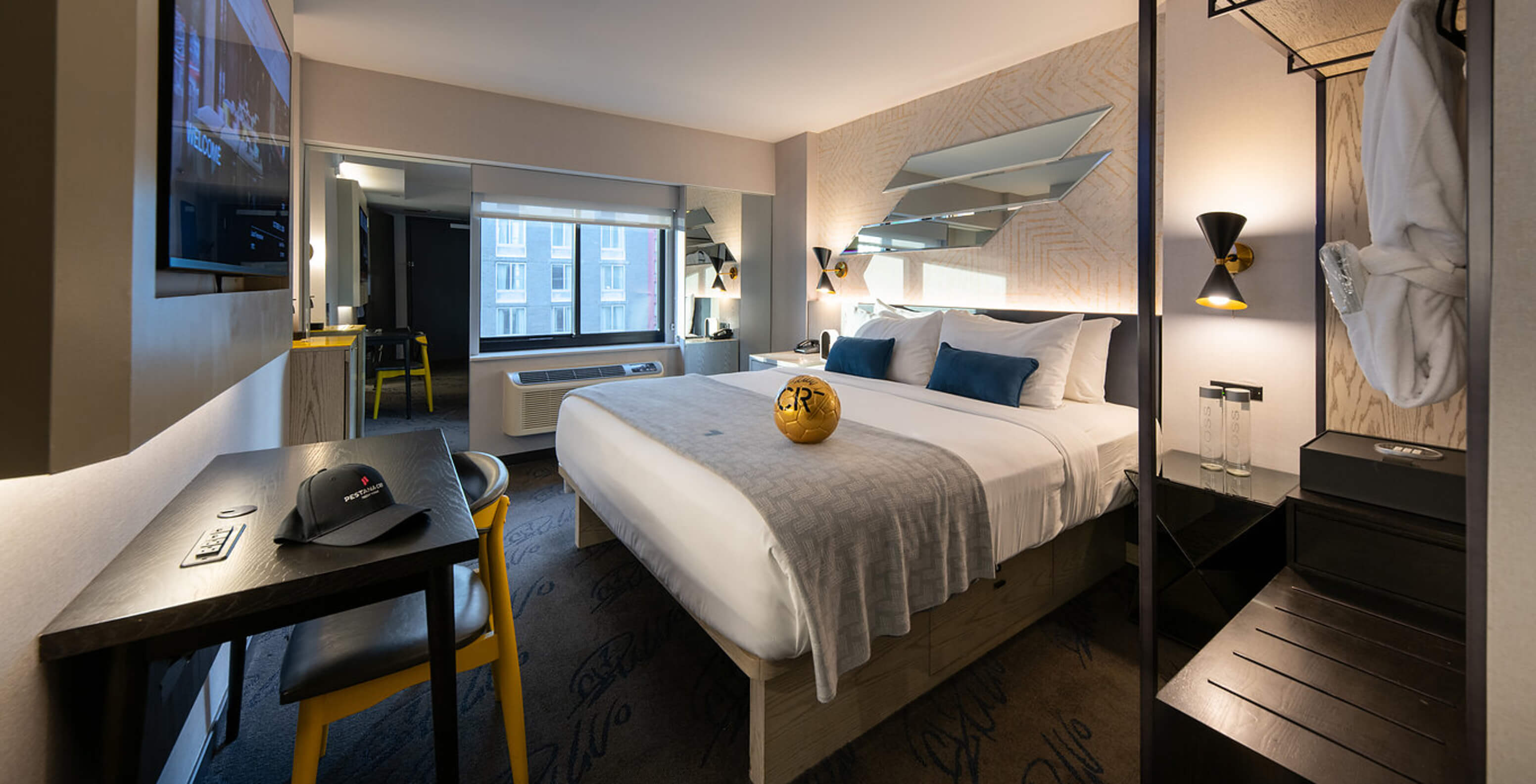 Das Deluxe King Room ADA im Pestana CR7 Times Square hat ein Doppelbett, einen Schreibtisch und einen Kleiderschrank