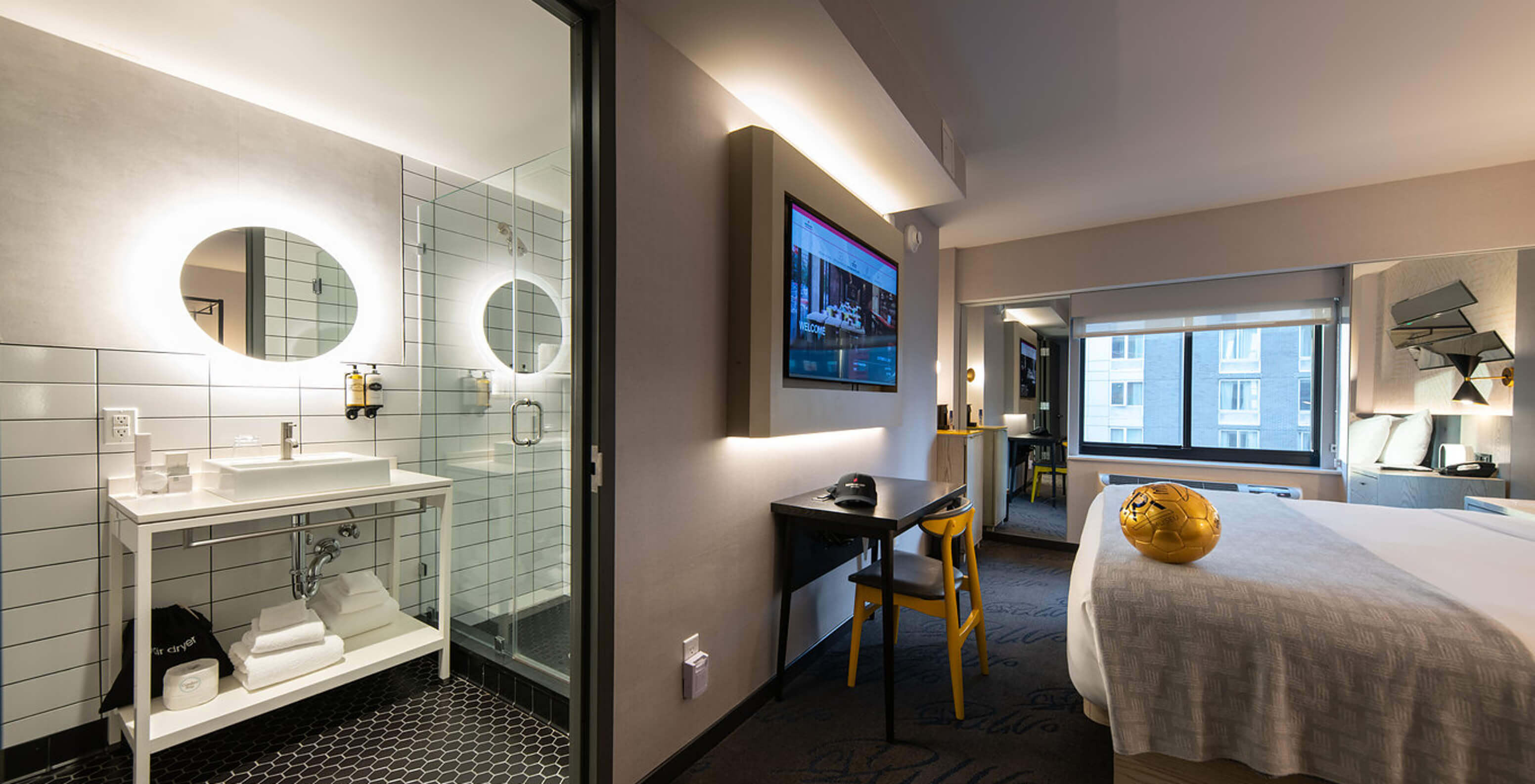 Das Deluxe King Room im Pestana CR7 Times Square hat ein Badezimmer neben dem Zimmer mit einem Waschbecken